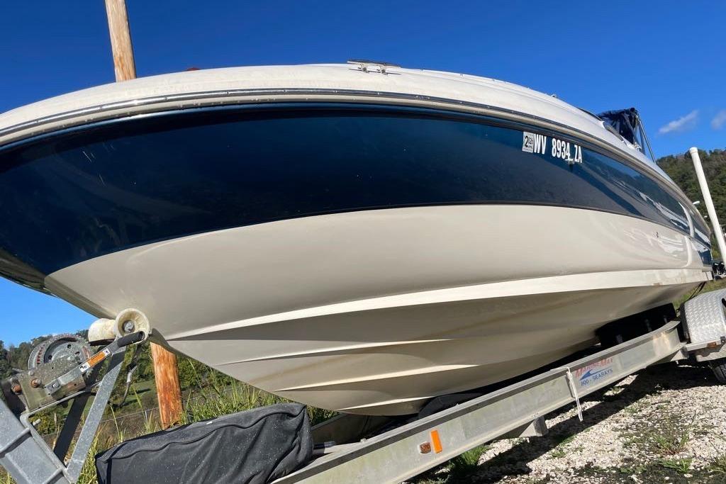 2004 Sea Ray 240 Sundeck boat on trailer under clear blue sky.