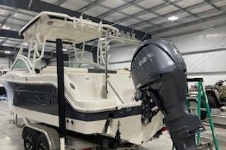 2022 Robalo R247 Dual Console boat in a storage facility with an outboard motor.