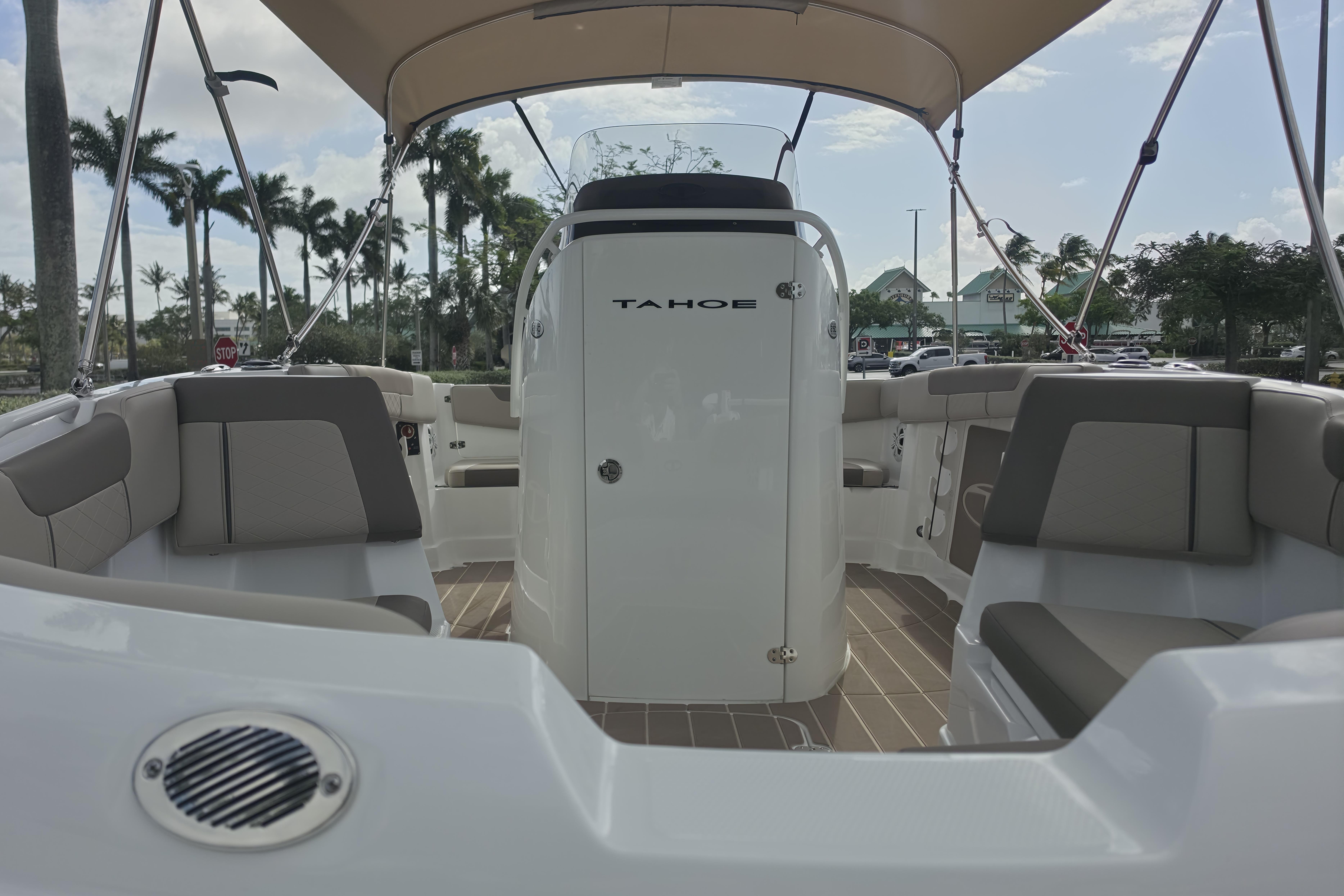 2026 Tahoe 2150 CC boat interior with seating and canopy, parked outdoors.