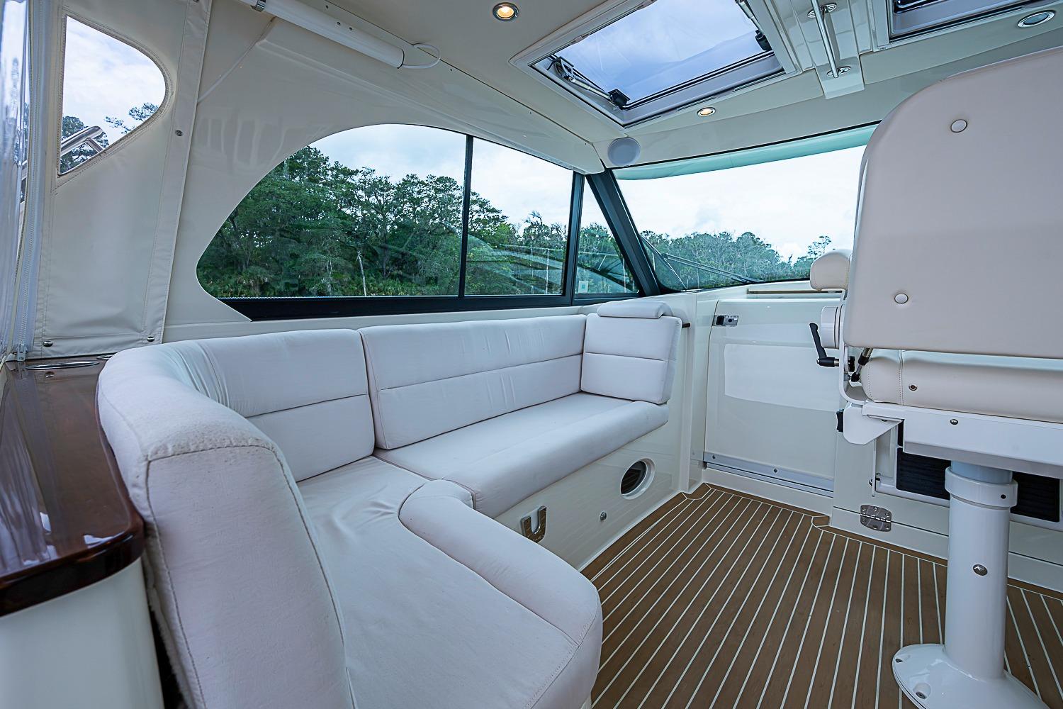 Interior of 2023 Hinckley Sport Boat 40 X with white seating and wood flooring.