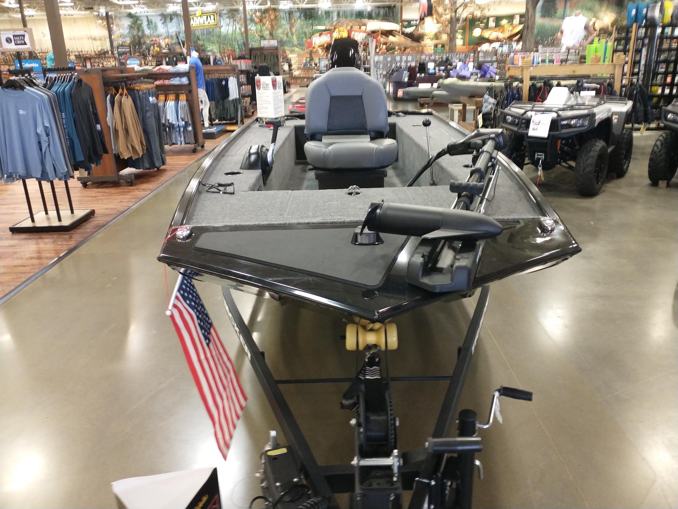 2025 Tracker Panfish 17 boat displayed indoors with American flag, surrounded by outdoor gear.