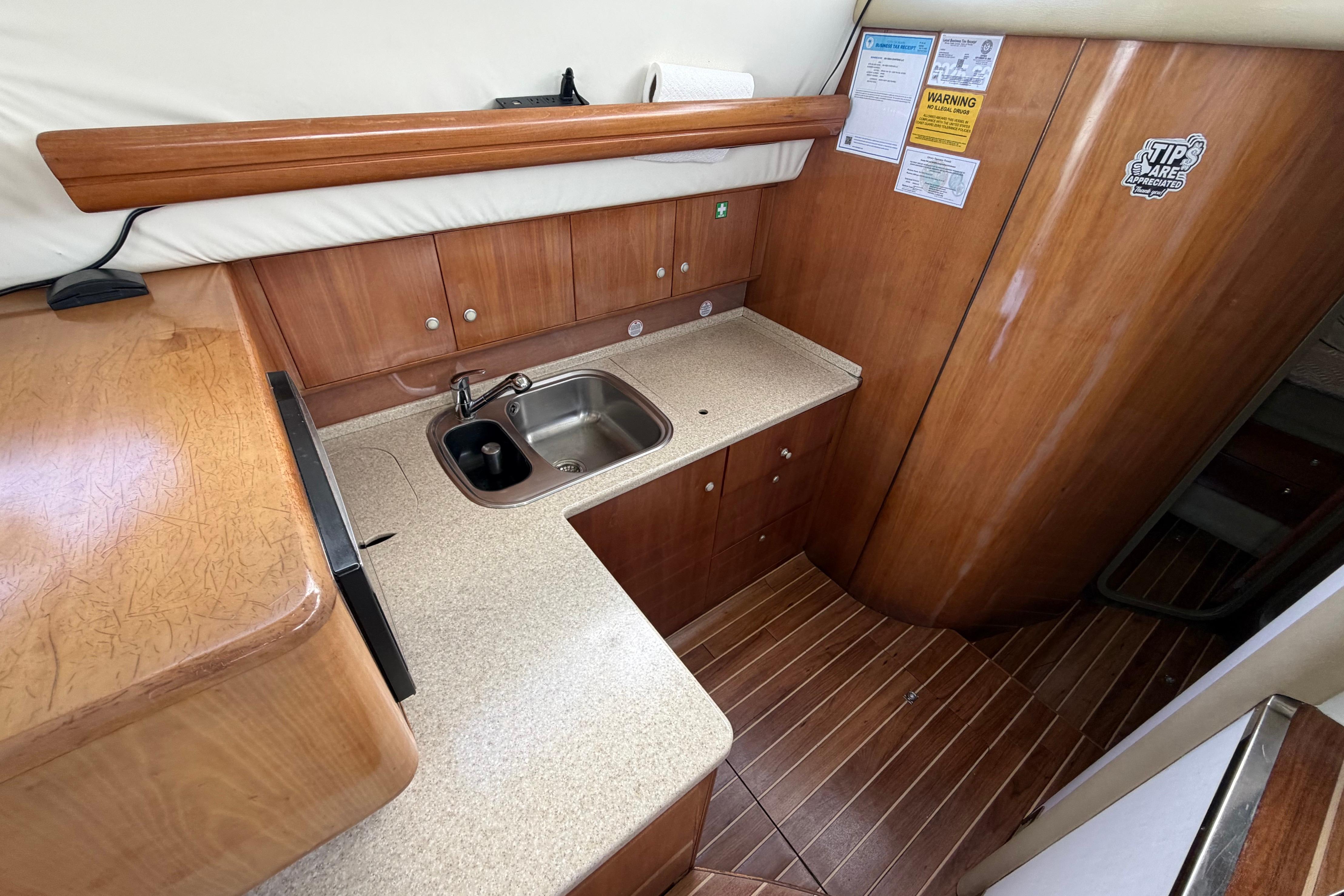 2007 Cranchi Atlantique 40 yacht kitchen with wooden cabinetry and stainless steel sink.