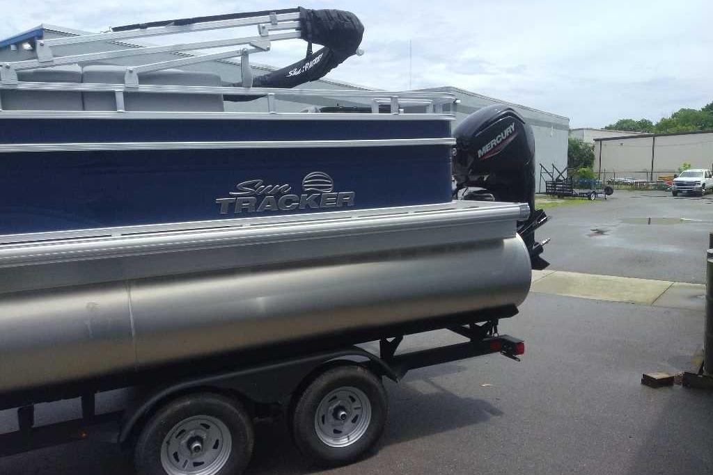 2026 Sun Tracker SportFish 20 DLX pontoon boat on trailer, featuring Mercury outboard motor.
