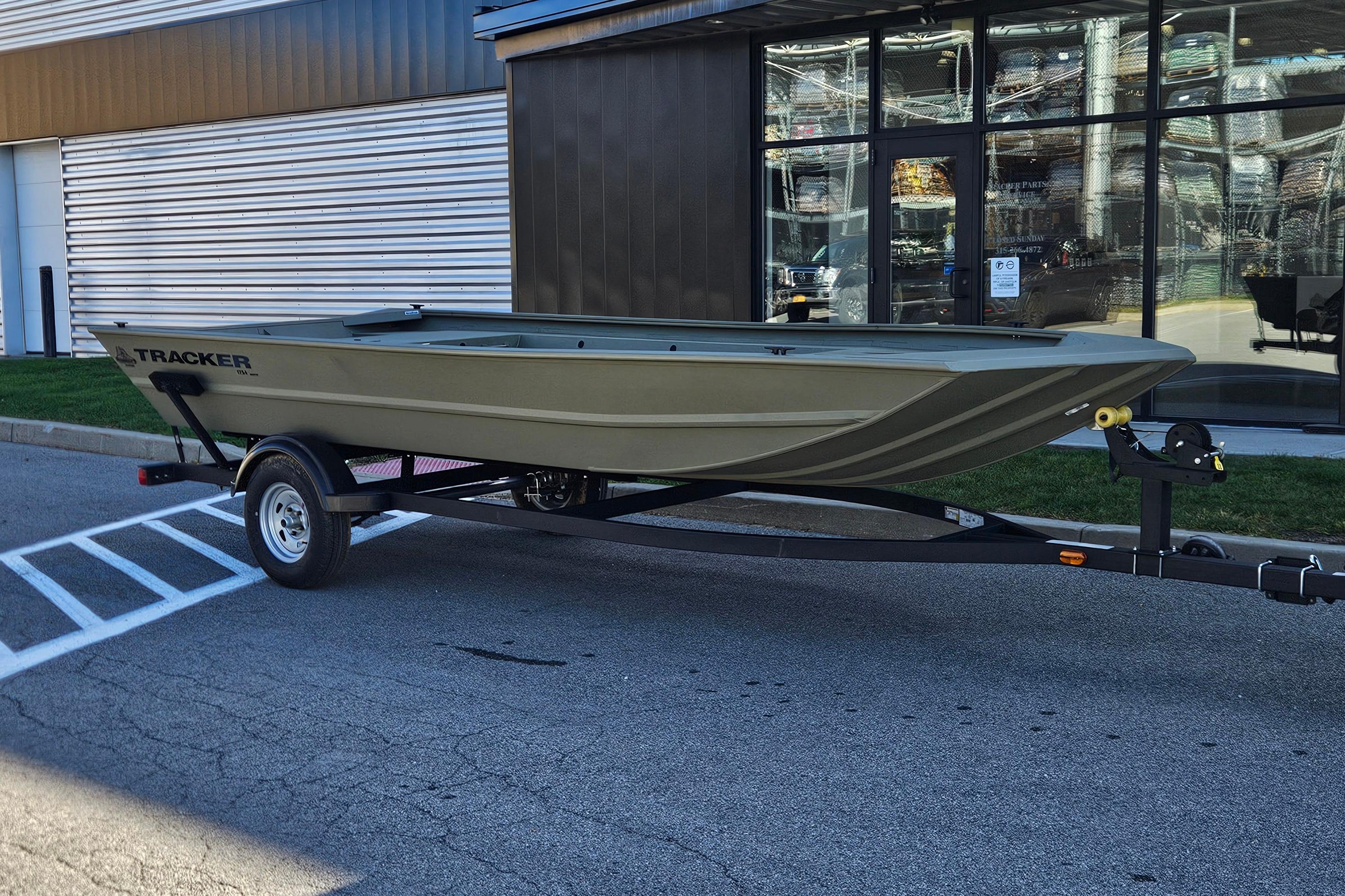 2026 Tracker Grizzly 1754 Utility boat on trailer outside a building.