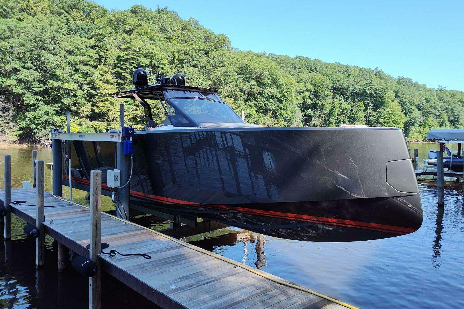 2023 Pardo Yachts P43 docked on a serene lake with lush green forest backdrop.