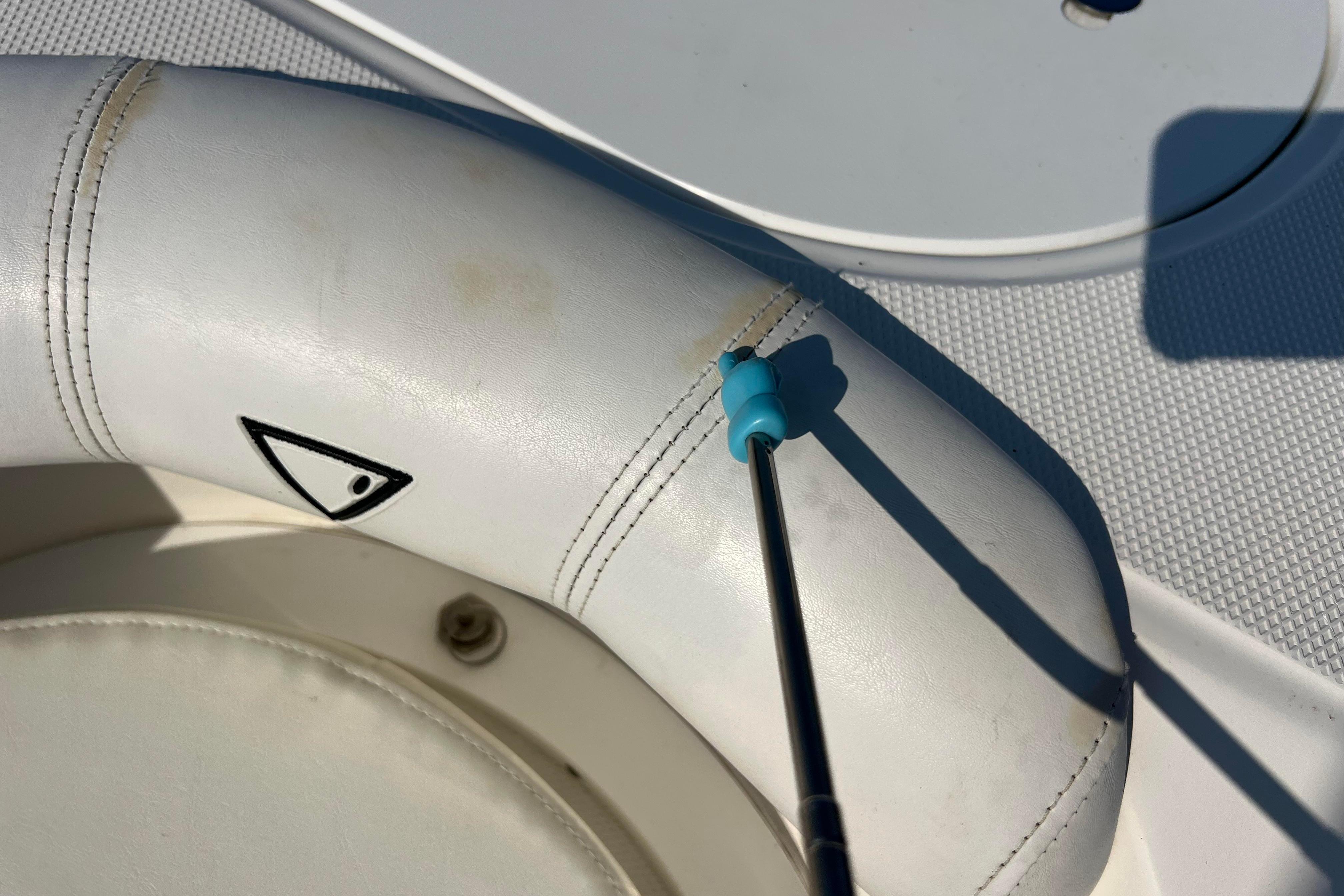 Close-up of a 2012 Sea Fox 206 Center Console boat seat with a cleaning tool.