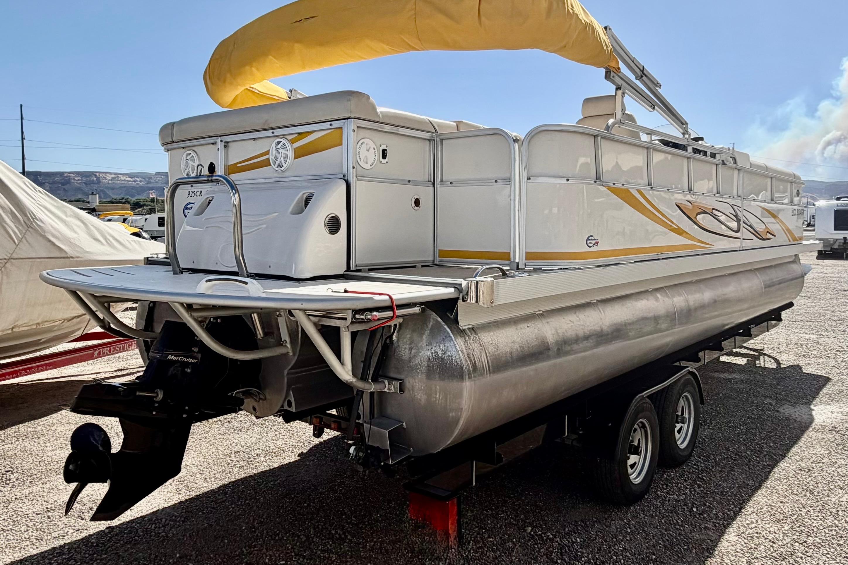 2006 South Bay 925CR pontoon boat with yellow canopy on trailer.