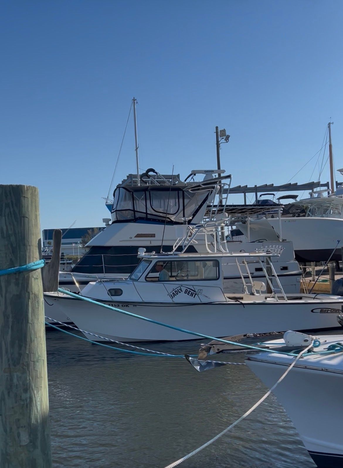 A 2009 May-Craft 2700 Pilot XL is docked in the harbor. Other boats are visible in the background.