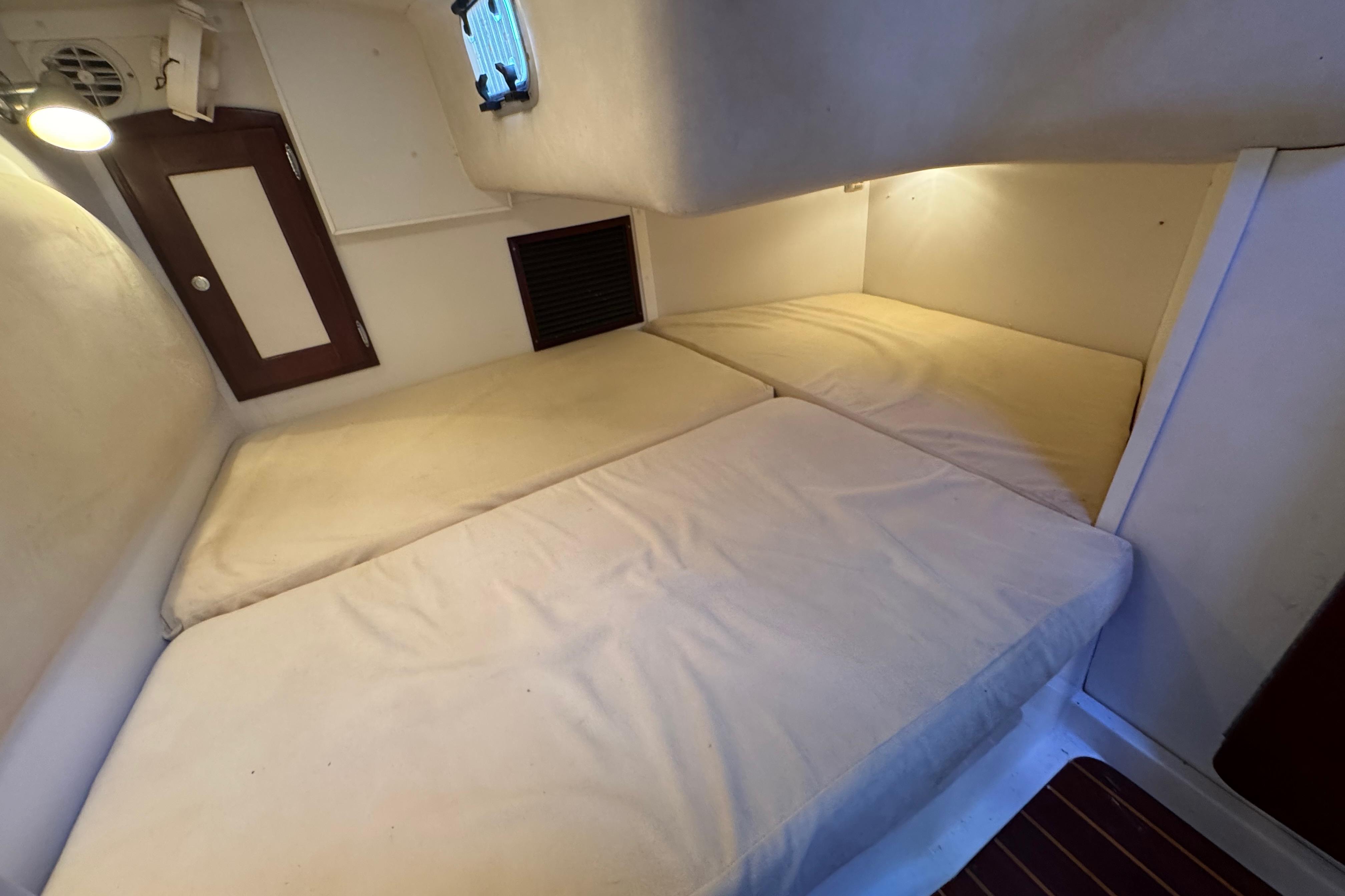 Cozy cabin interior of 2006 Shannon Shoalsailer with twin beds and soft lighting.