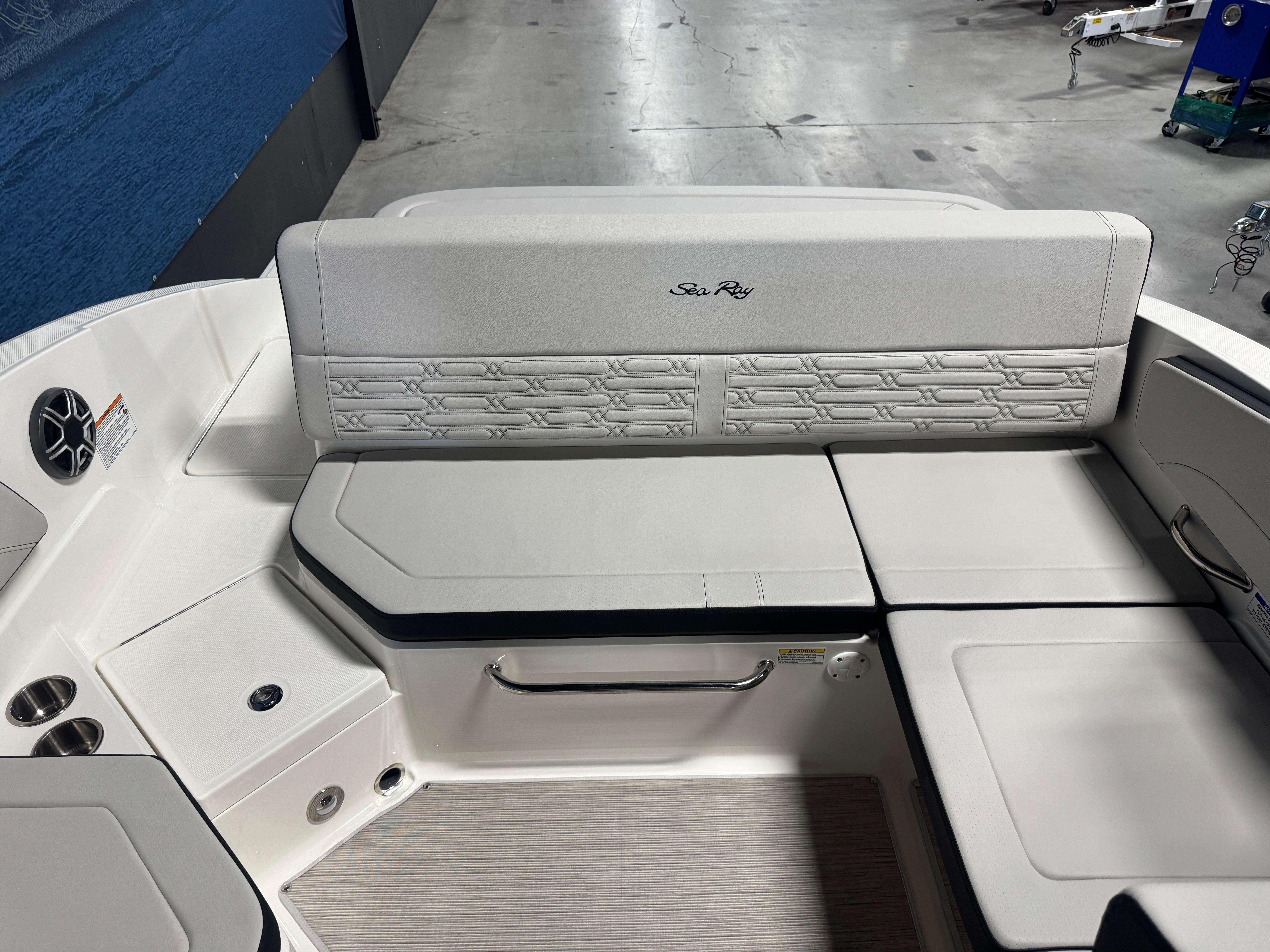2026 Sea Ray SPX 210 boat interior with white cushioned seating and speaker.