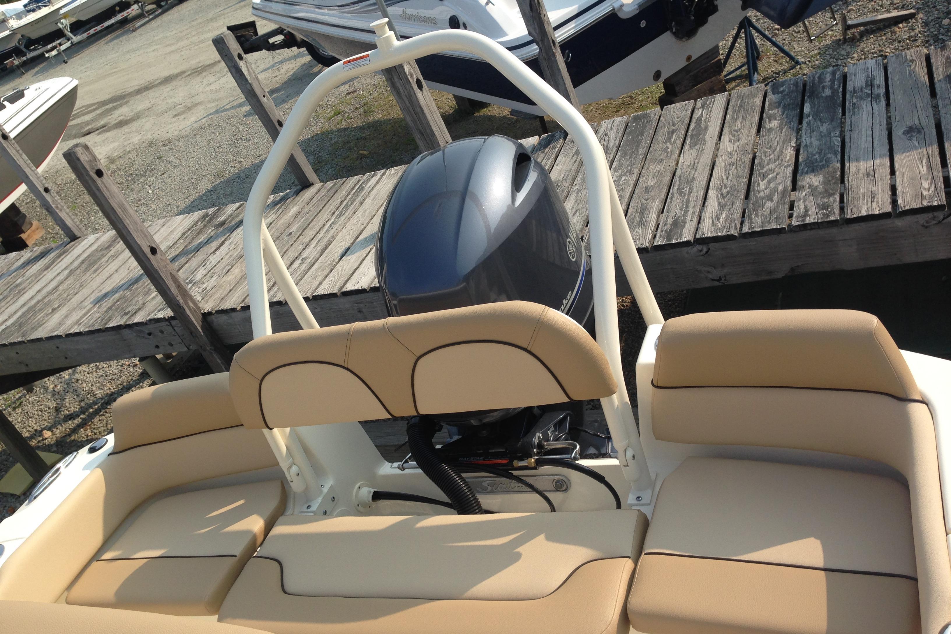 2026 Scout 195 Sportfish boat with beige seating and outboard motor at dock.
