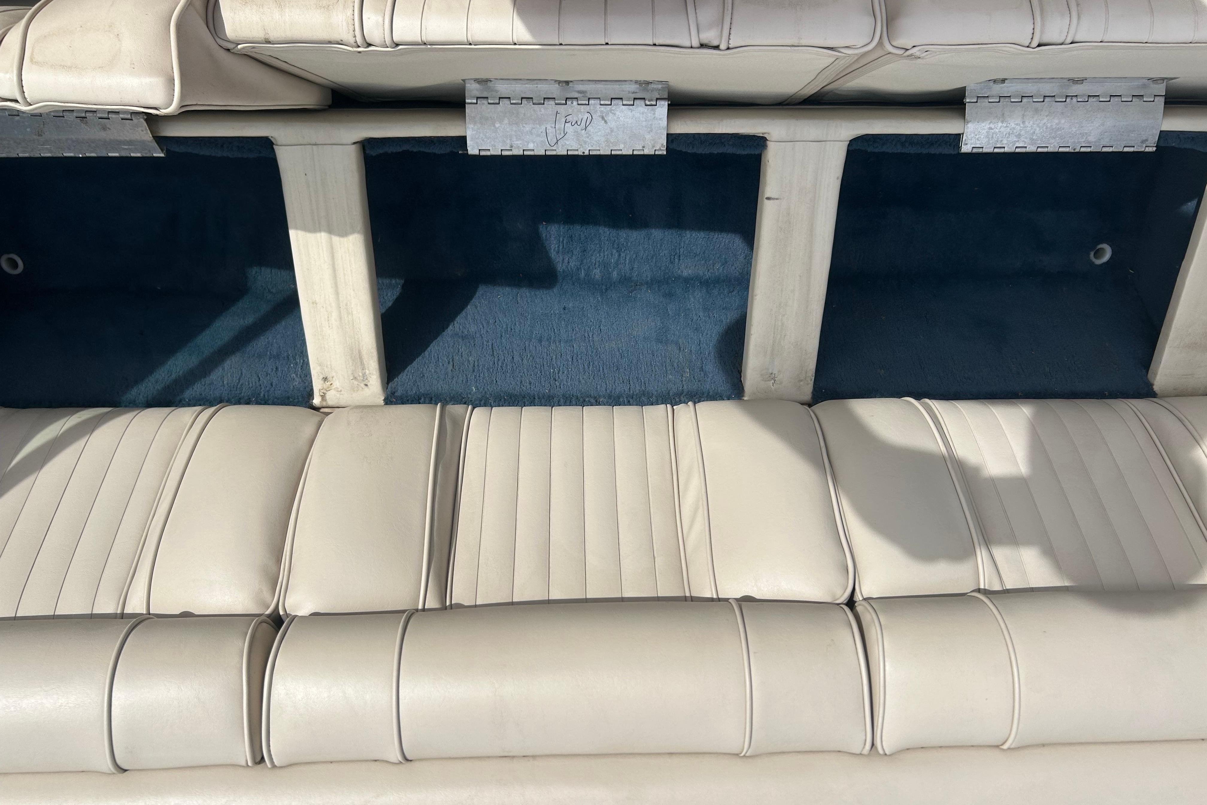 Interior seating of a 1996 Mariah 180 Shabah boat with white upholstery and storage compartments.