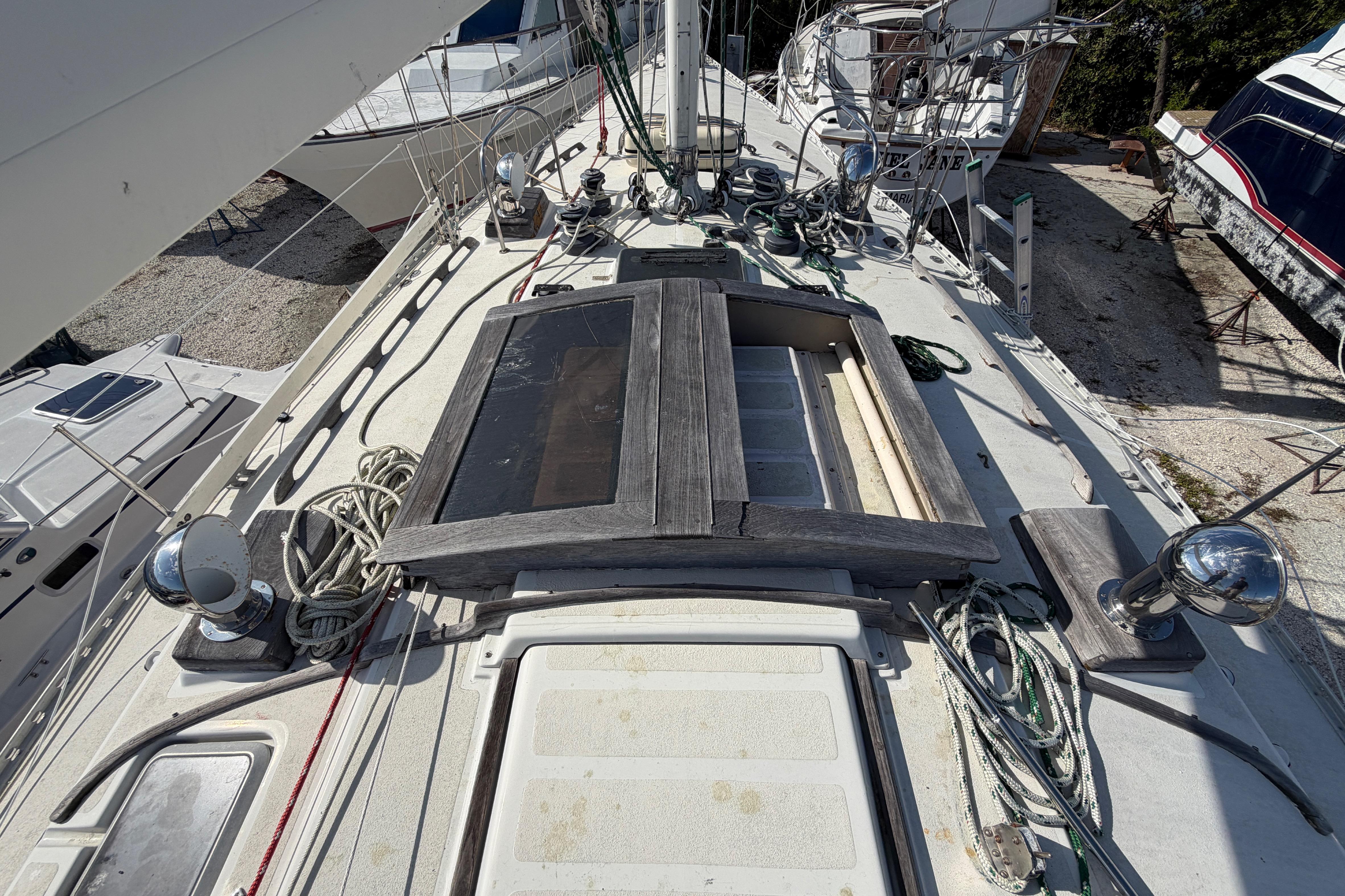 1983 Morgan Catilina sailboat deck with ropes and equipment, docked among other boats.