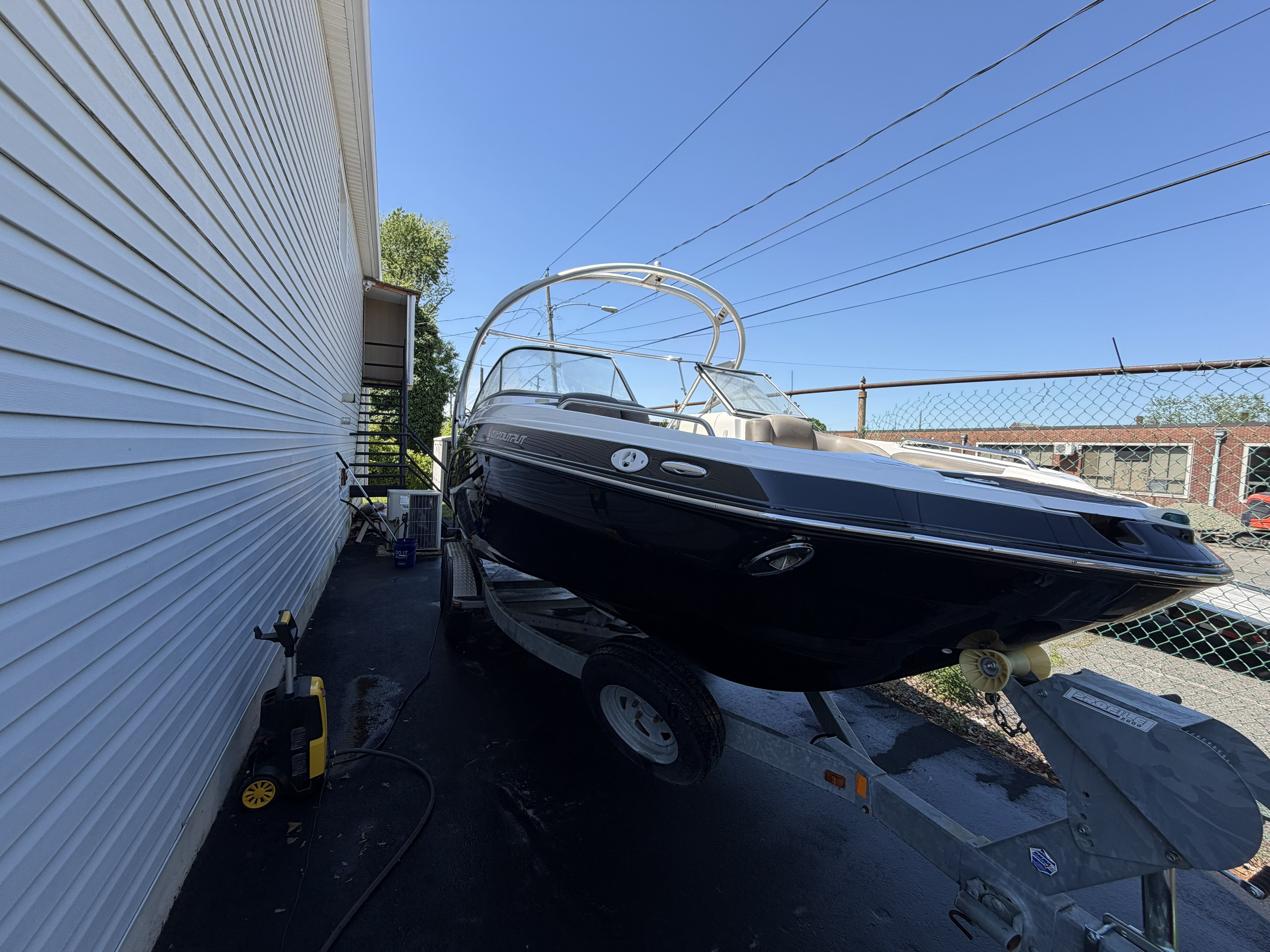 2012 Yamaha 242 boat on a trailer beside a building.
