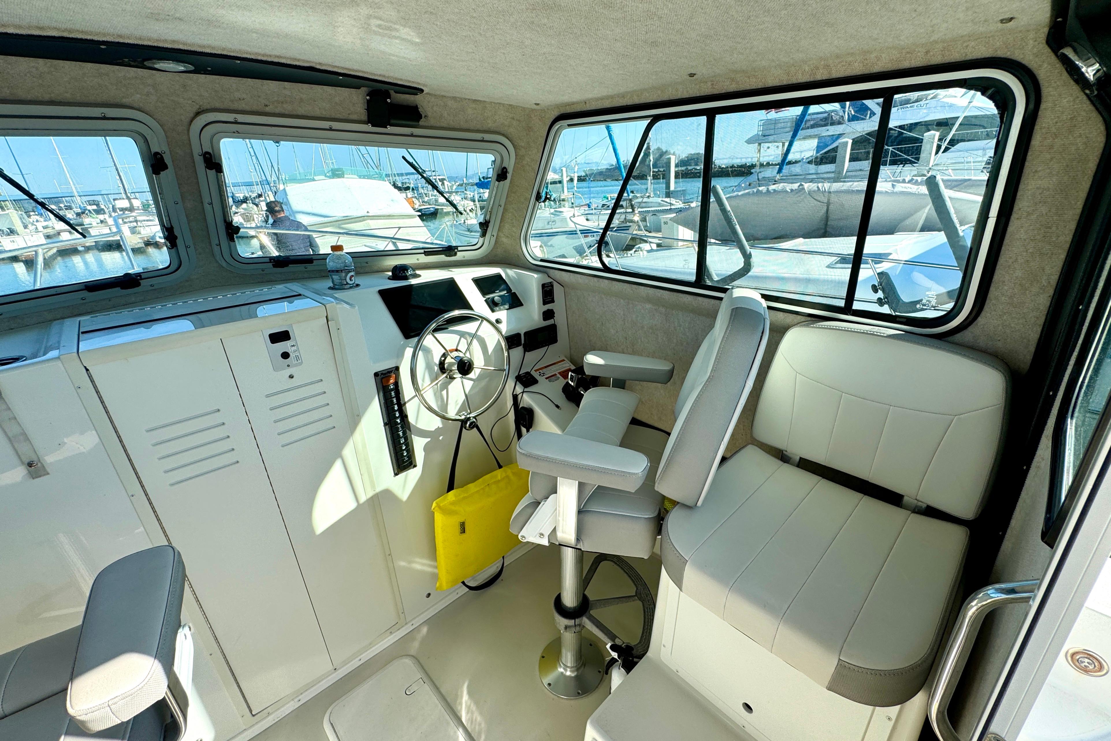 Interior of 2021 Parker 2820 XLD Sport Cabin with helm and seating, docked at marina.