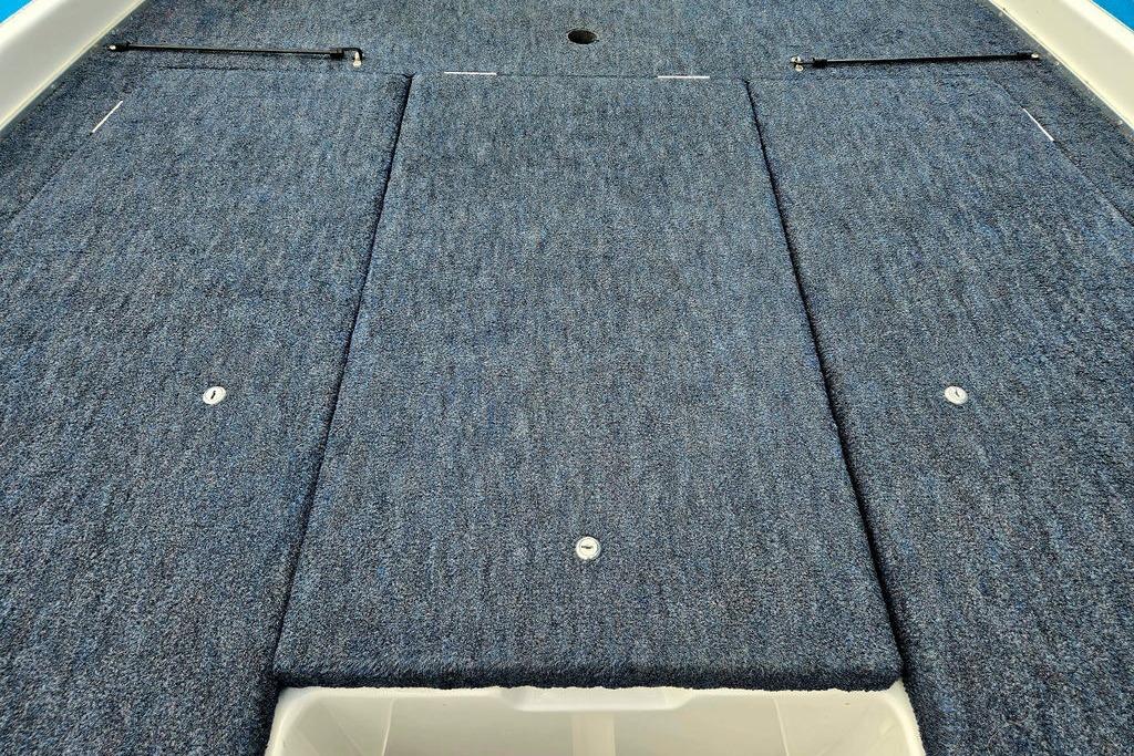 1996 Champion 181 SX boat deck with blue carpet and storage compartments.