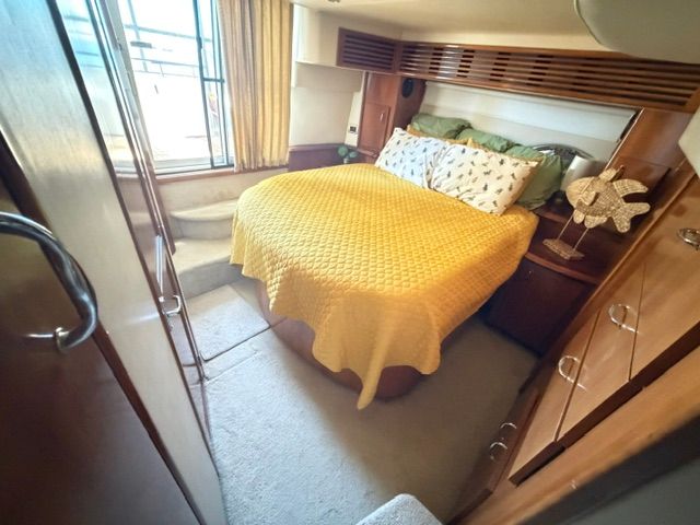 Cabin with a cozy bed, yellow blanket, and wooden furnishings.