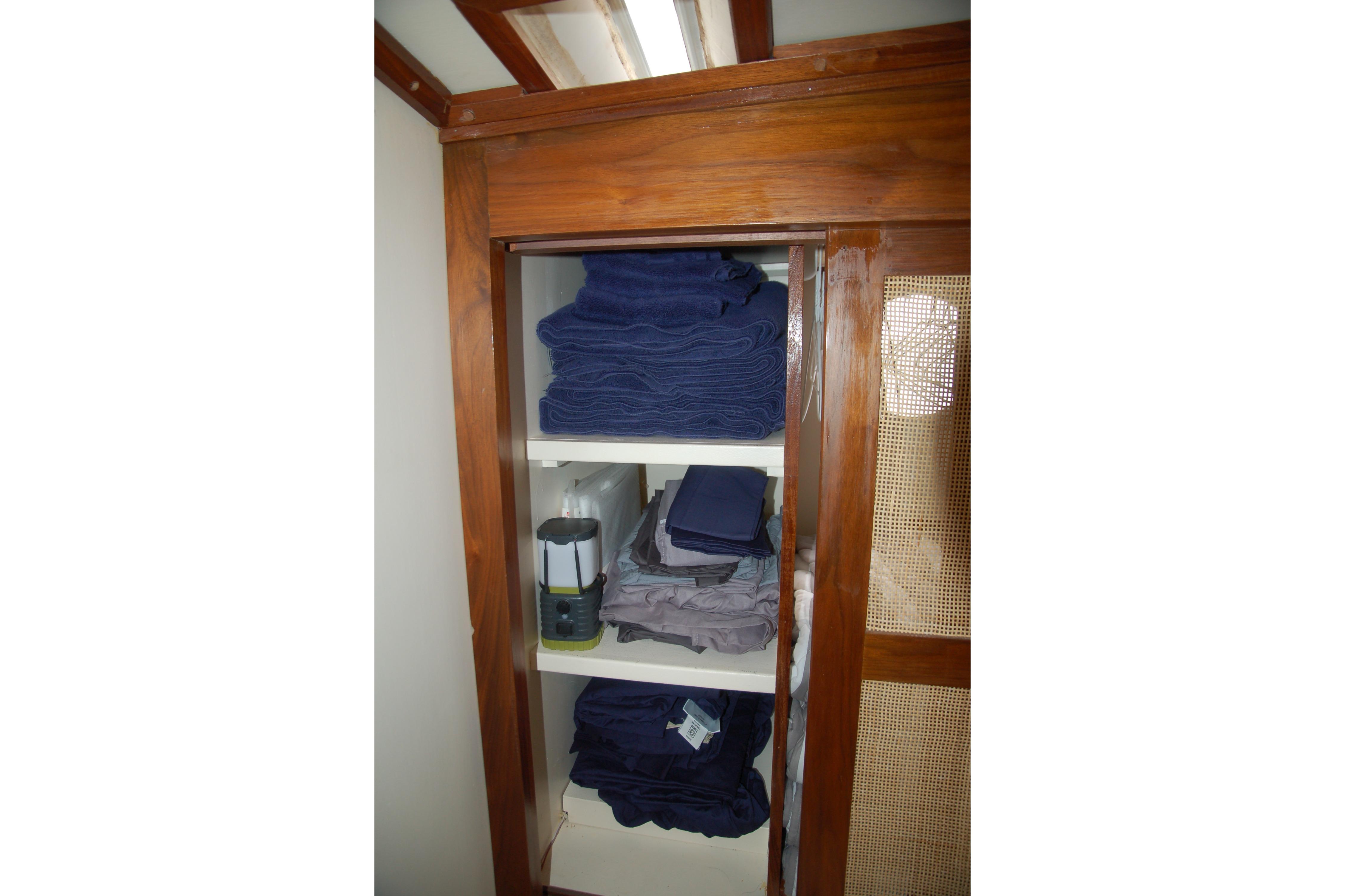 Wooden cabinet with neatly stacked blue and gray towels, Custom Sprague 2006 model.