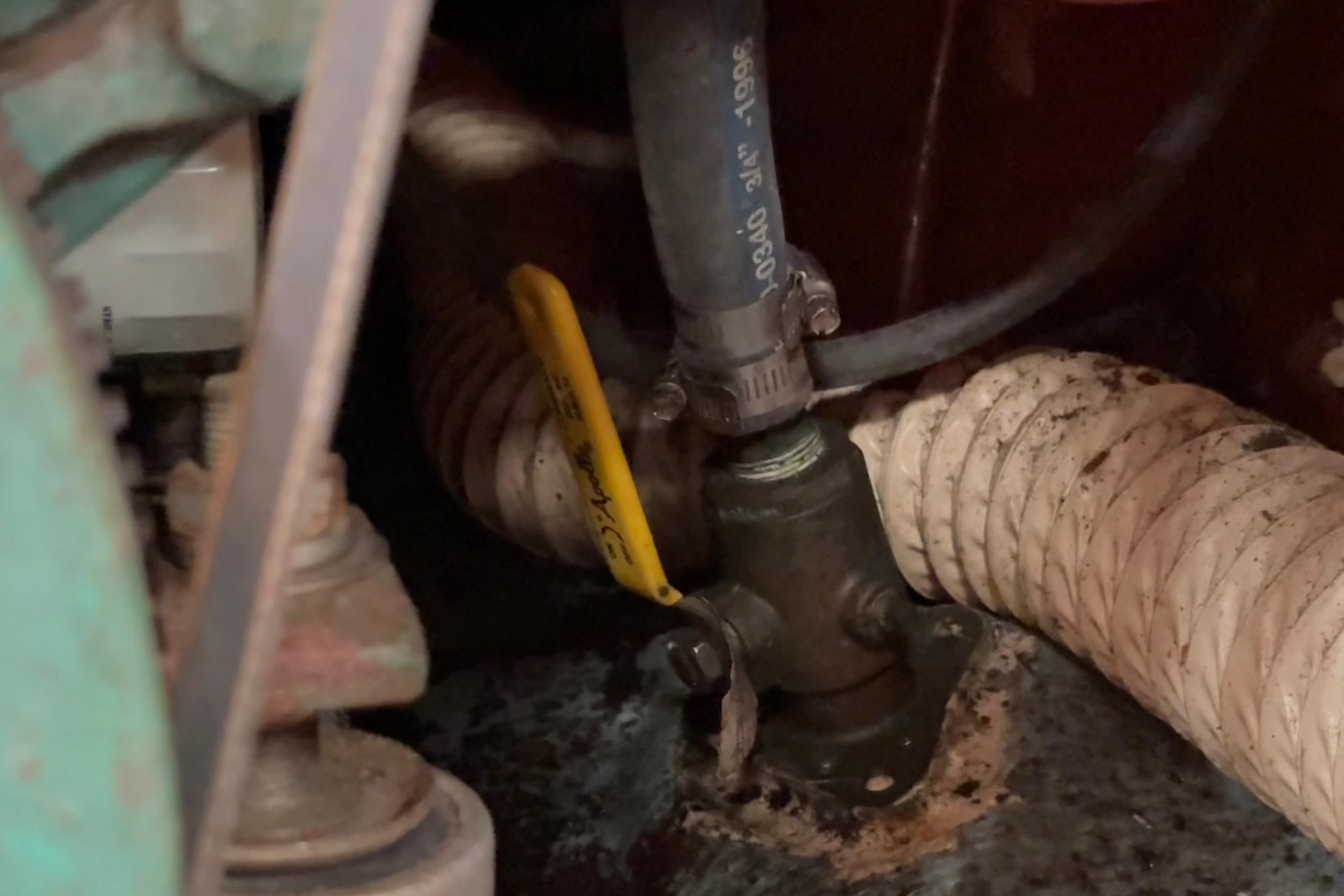 Engine compartment of a 1981 Sabre 31 sailboat showing hoses and fittings.