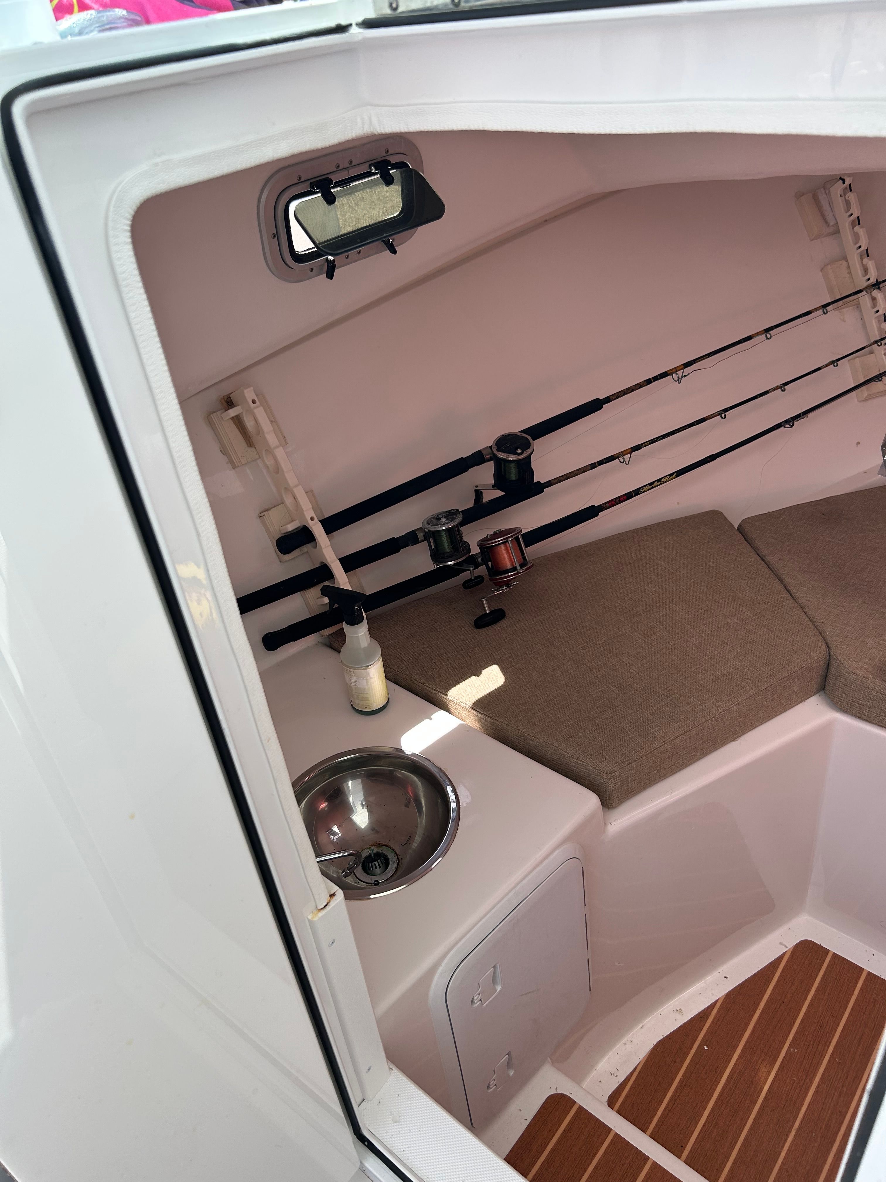 Interior of the Steiger Craft 28 Miami with fishing rods and a sink.
