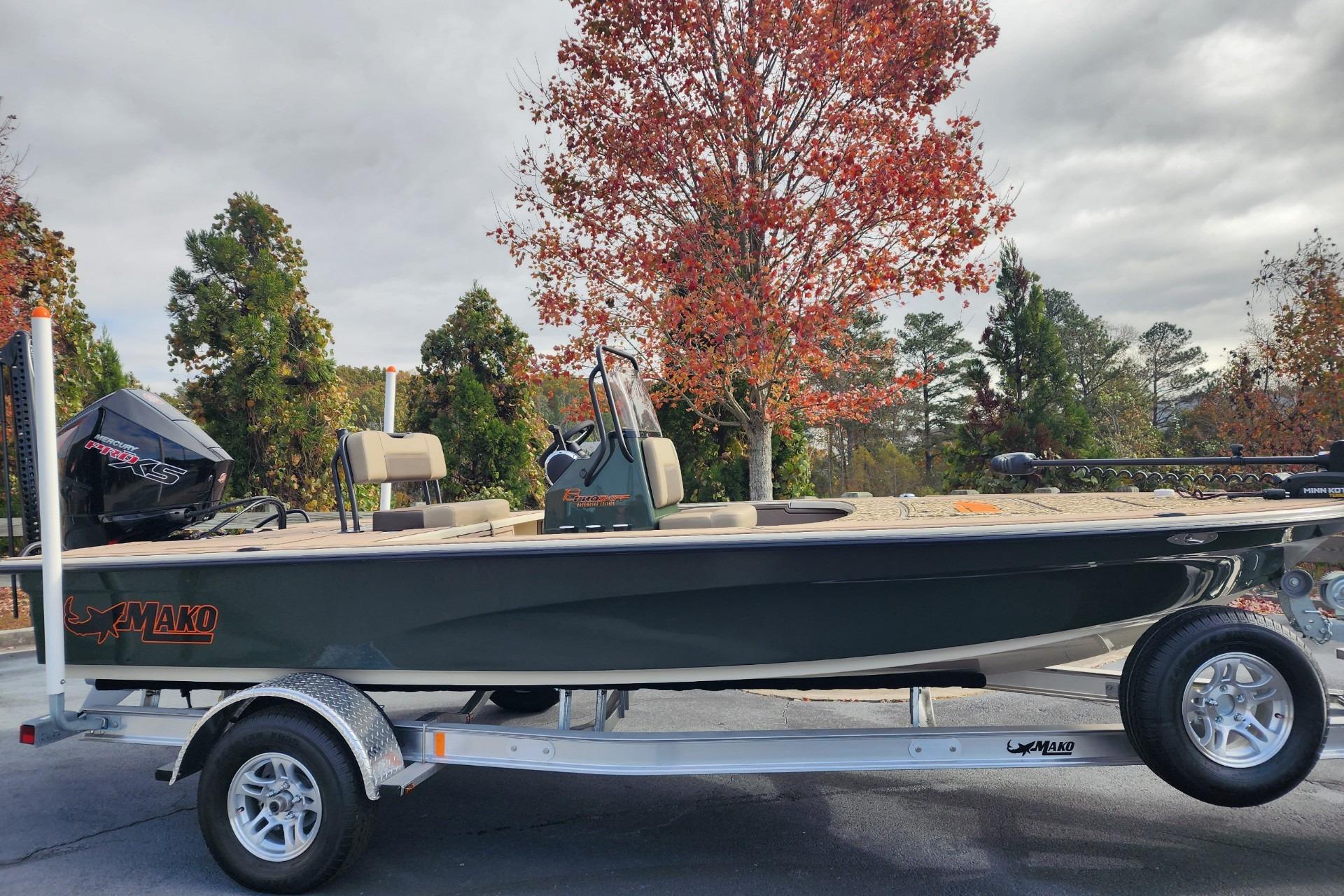 2025 Mako 18 Pro Skiff Backwater Edition on trailer, surrounded by autumn trees.