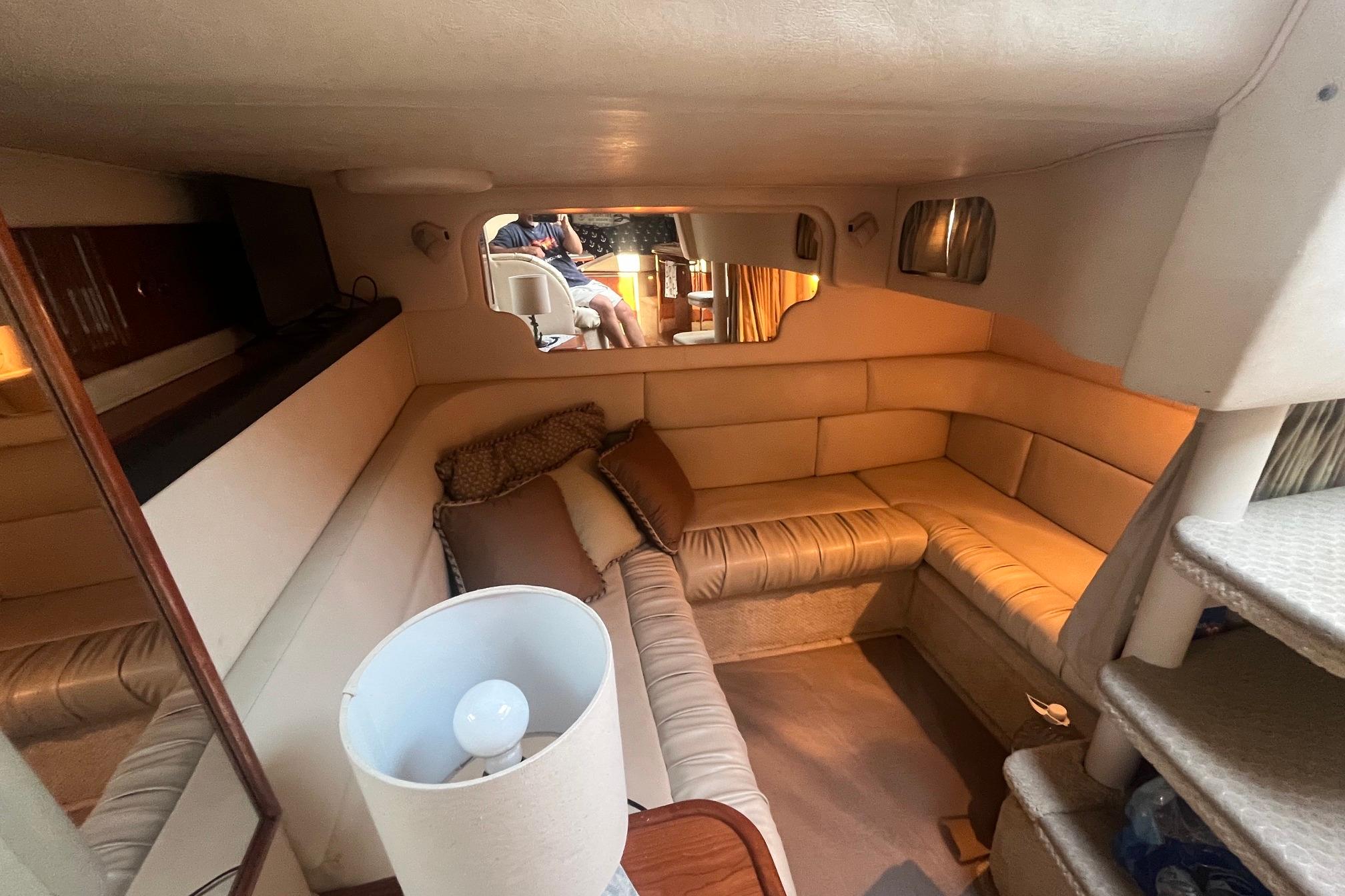 Interior of 2001 Sea Ray 340 Sundancer yacht with cozy seating and ambient lighting.