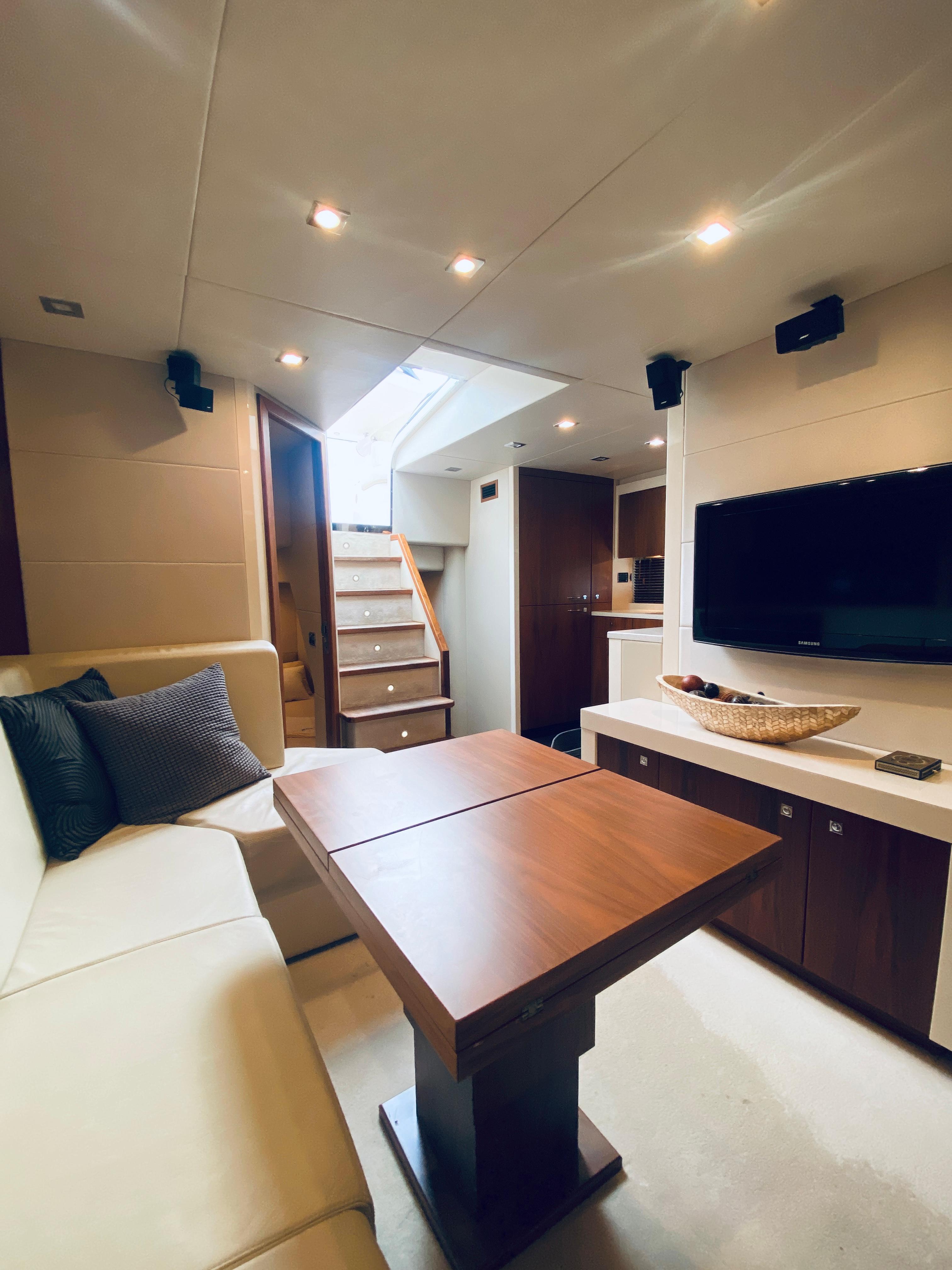 Luxurious interior of 2010 Sunseeker Predator 60 yacht with modern furnishings and entertainment system.