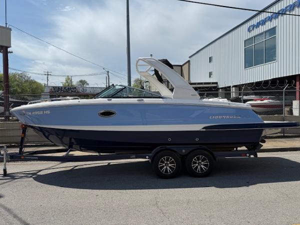 2023 Chaparral 267 SSX boat on trailer, parked outdoors near industrial building.