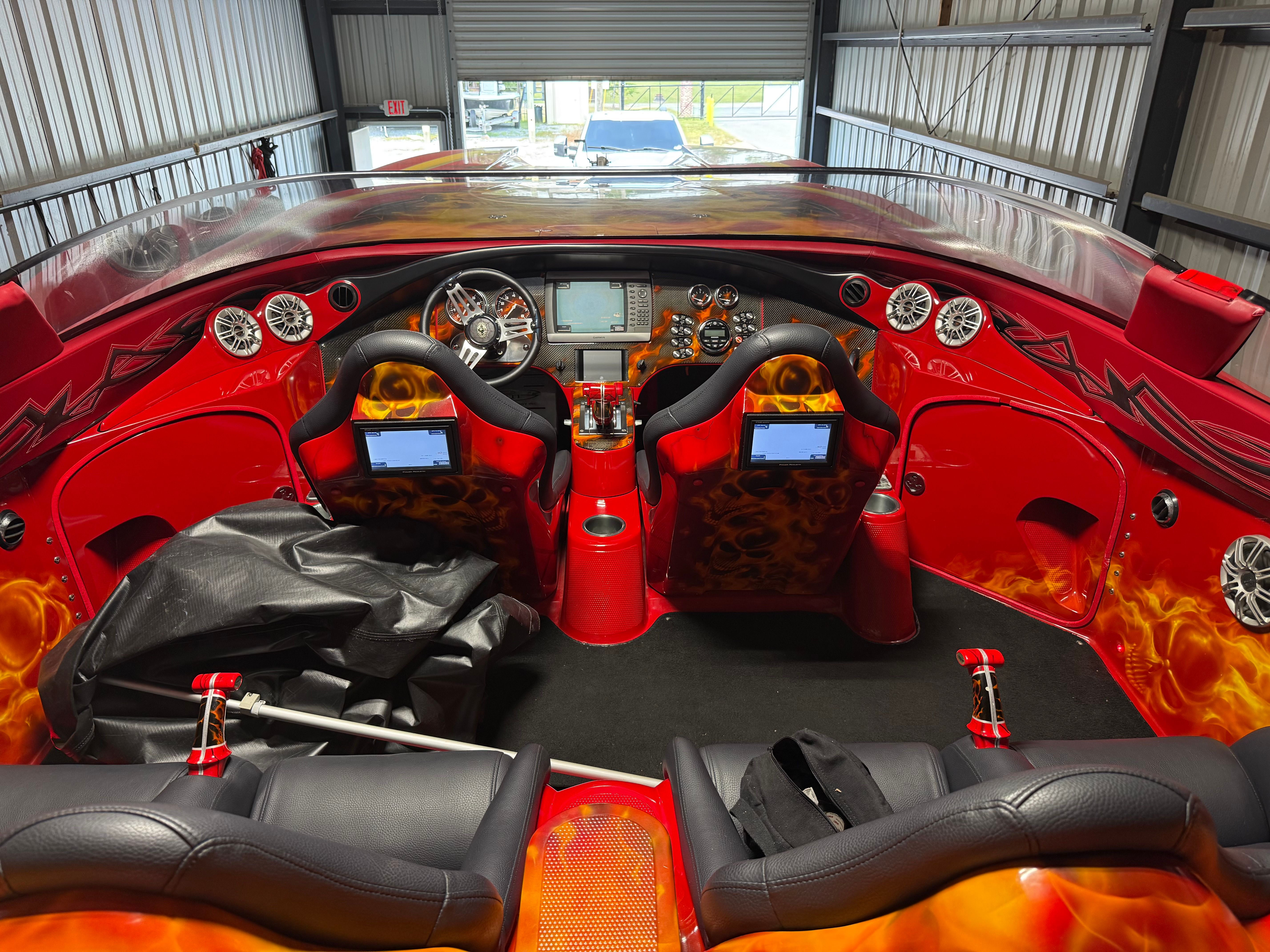 The image shows the cockpit of a 2010 MTI CAT with bright red interior and flame design.
