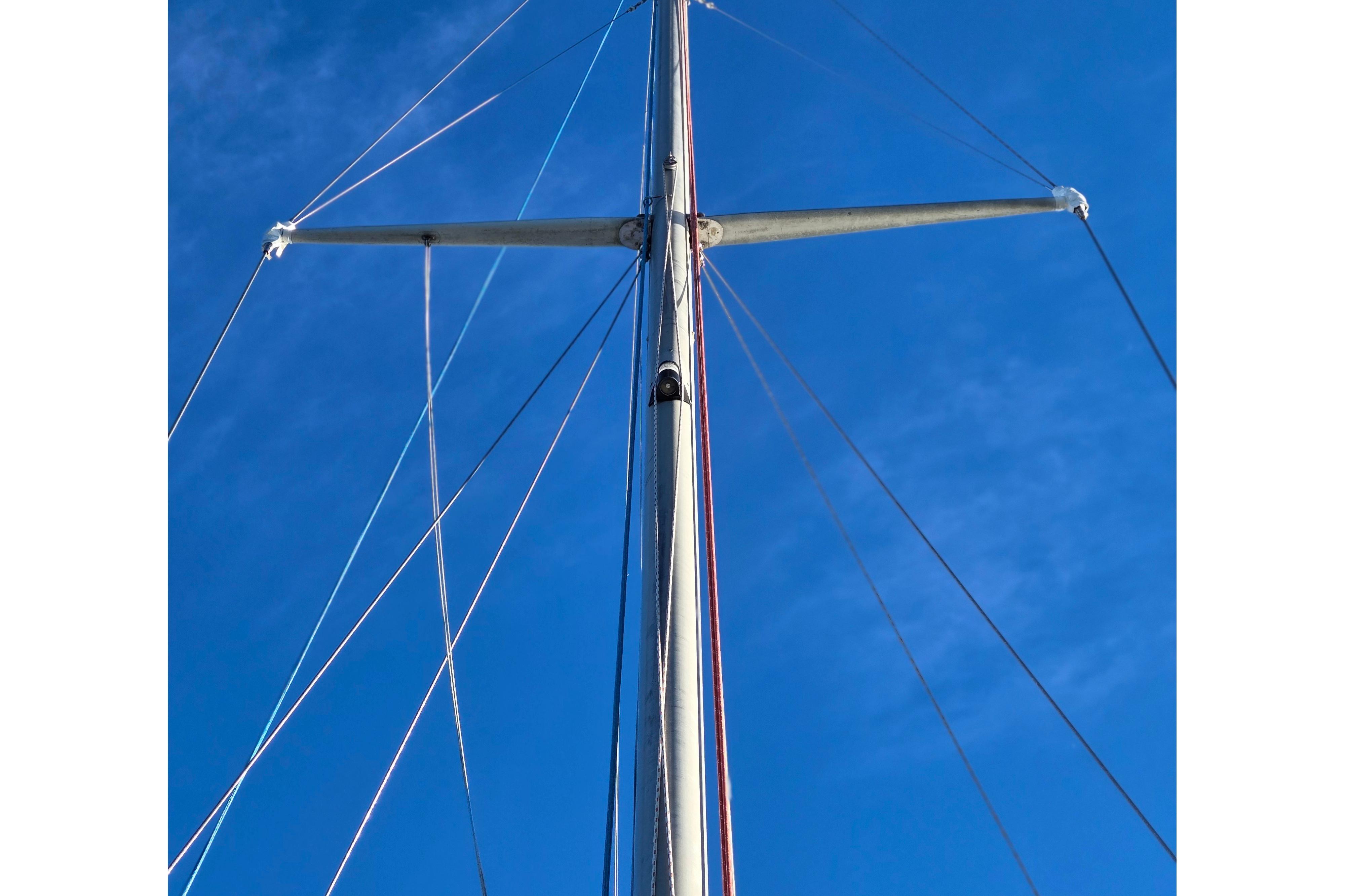 Mast and rigging of a 1970 Hinckley Bermuda 40 sailboat against a clear blue sky.