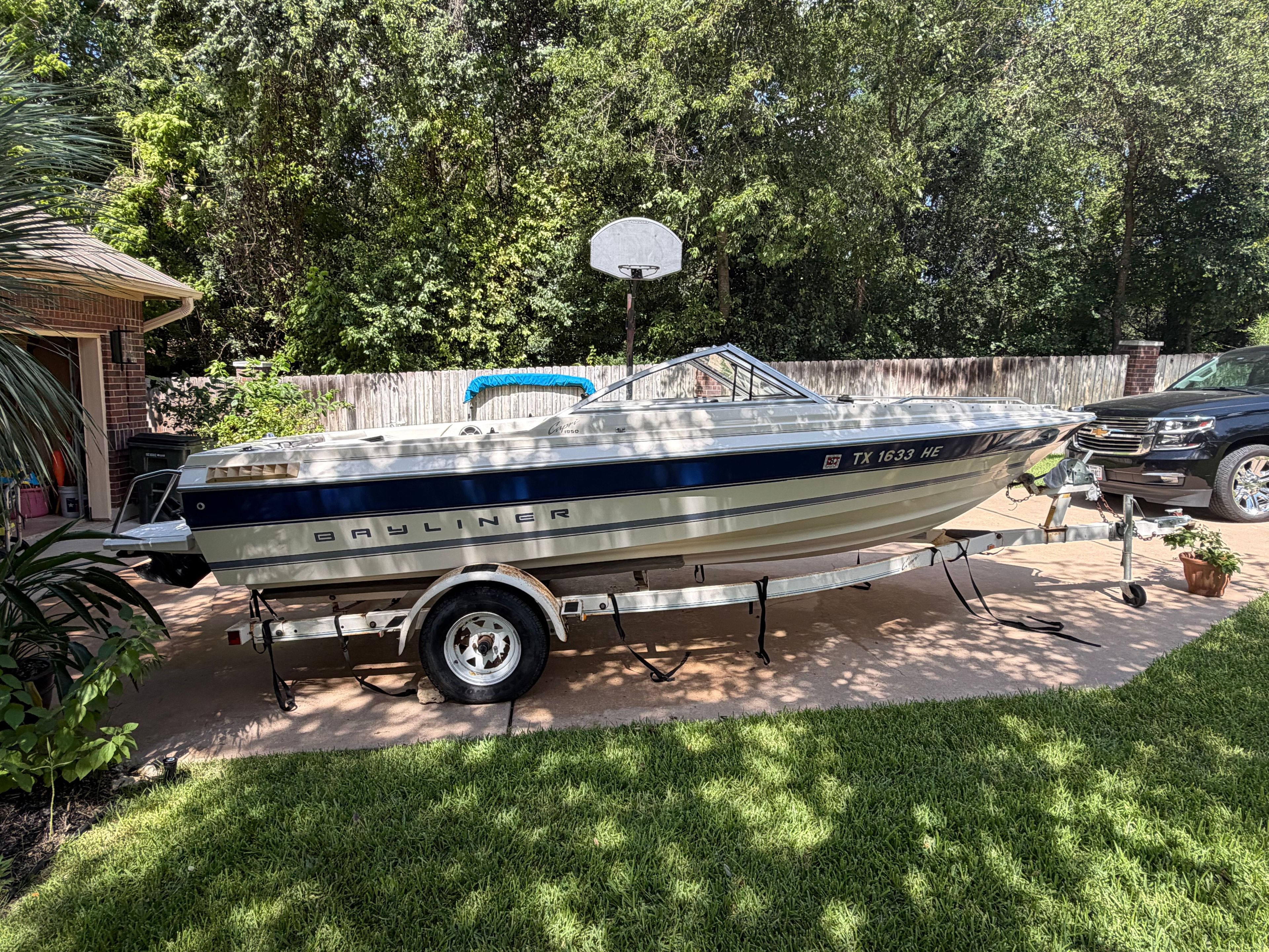 A 1994 Bayliner CAPRI on a trailer in a backyard setting.