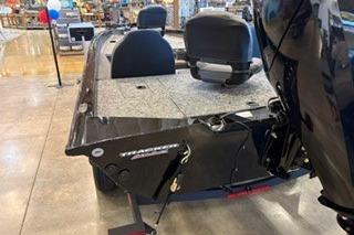 2026 Tracker Pro Team 175 boat displayed indoors, showcasing seating and motor.