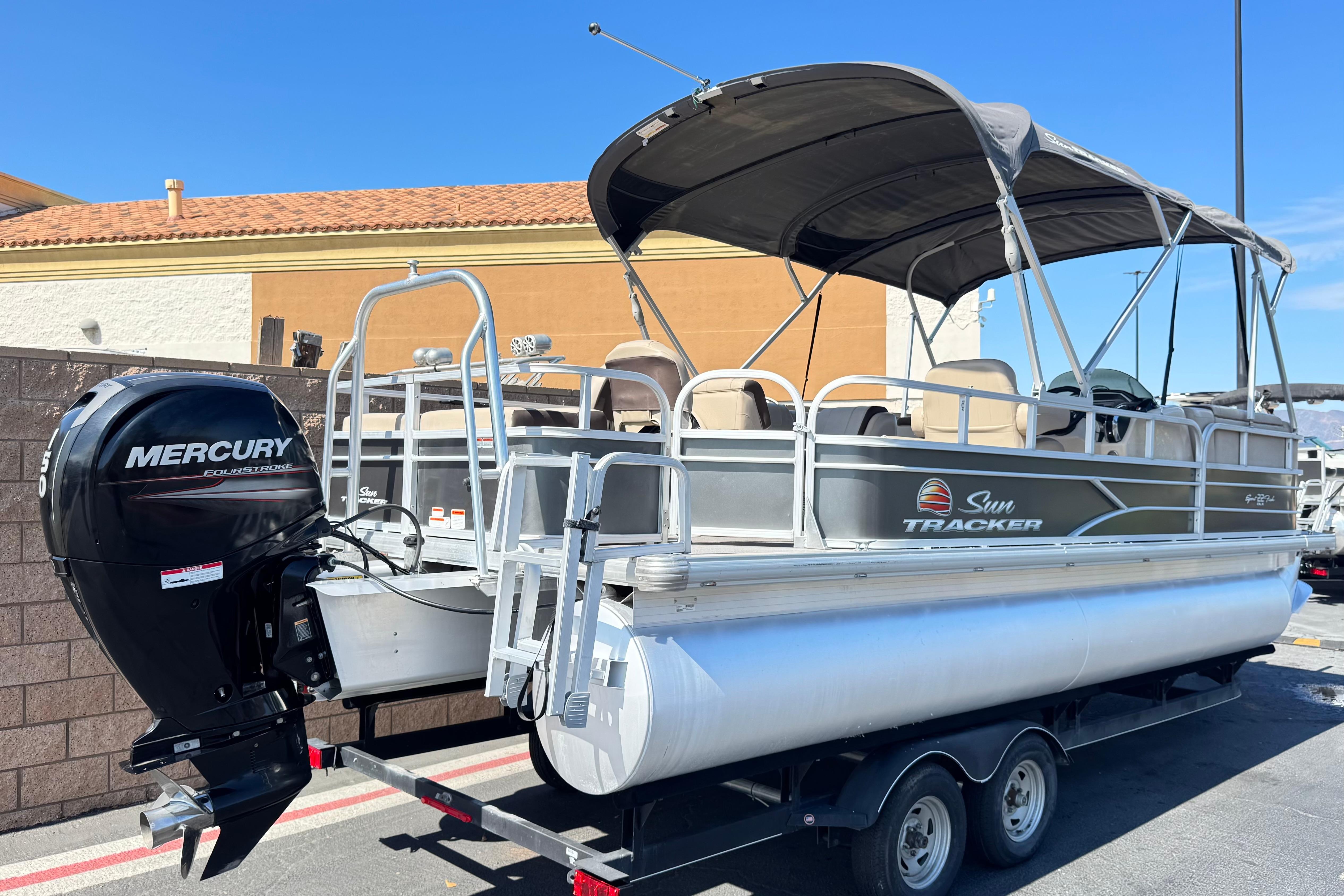 2018 Sun Tracker SportFish 22 DLX pontoon boat with Mercury outboard motor on trailer.
