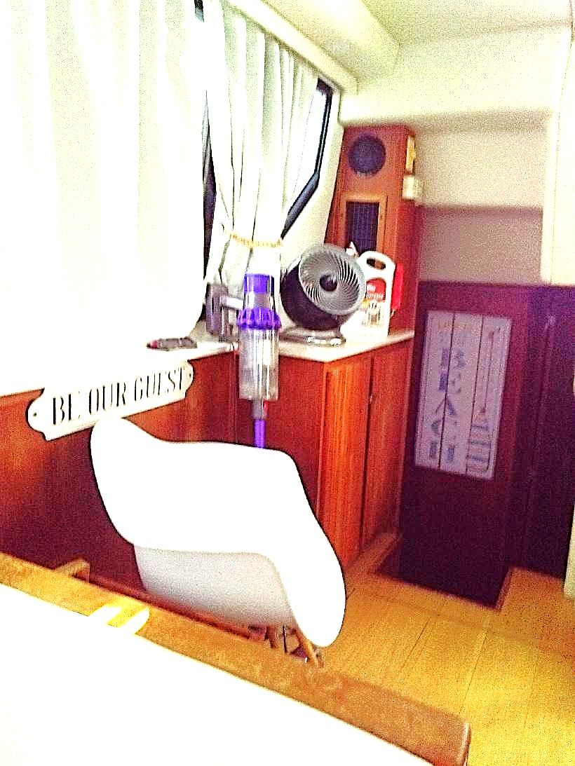 Interior of a 1995 Carver 35 with white furniture and wooden cabinetry.