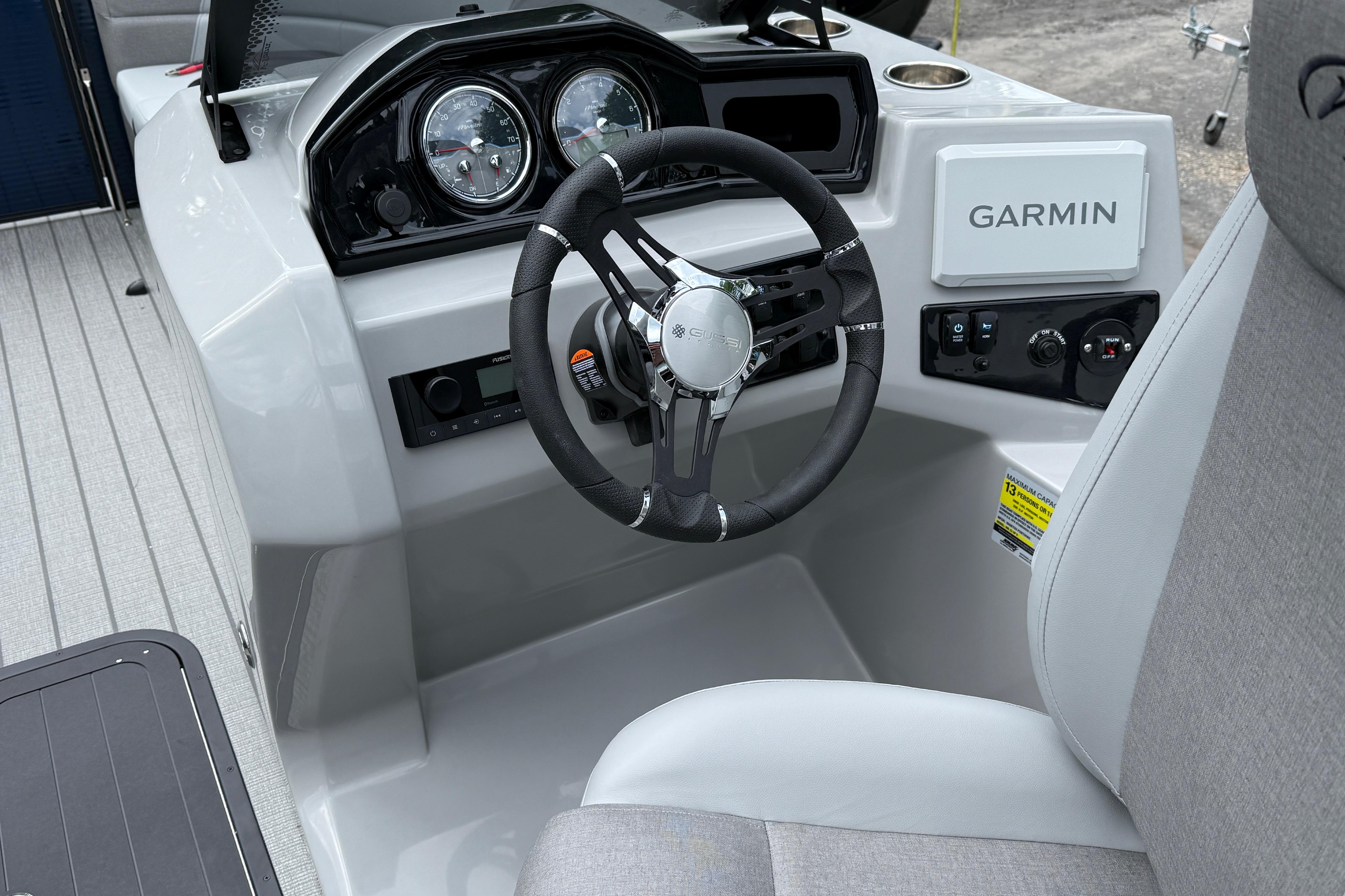 2027 Manitou Aurora RF 23 boat dashboard with Garmin navigation system and steering wheel.