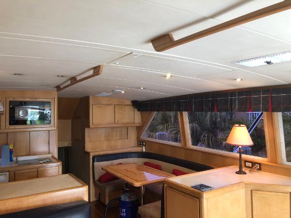 1997 Bertram Convertible yacht interior with wooden cabinetry and dining area.