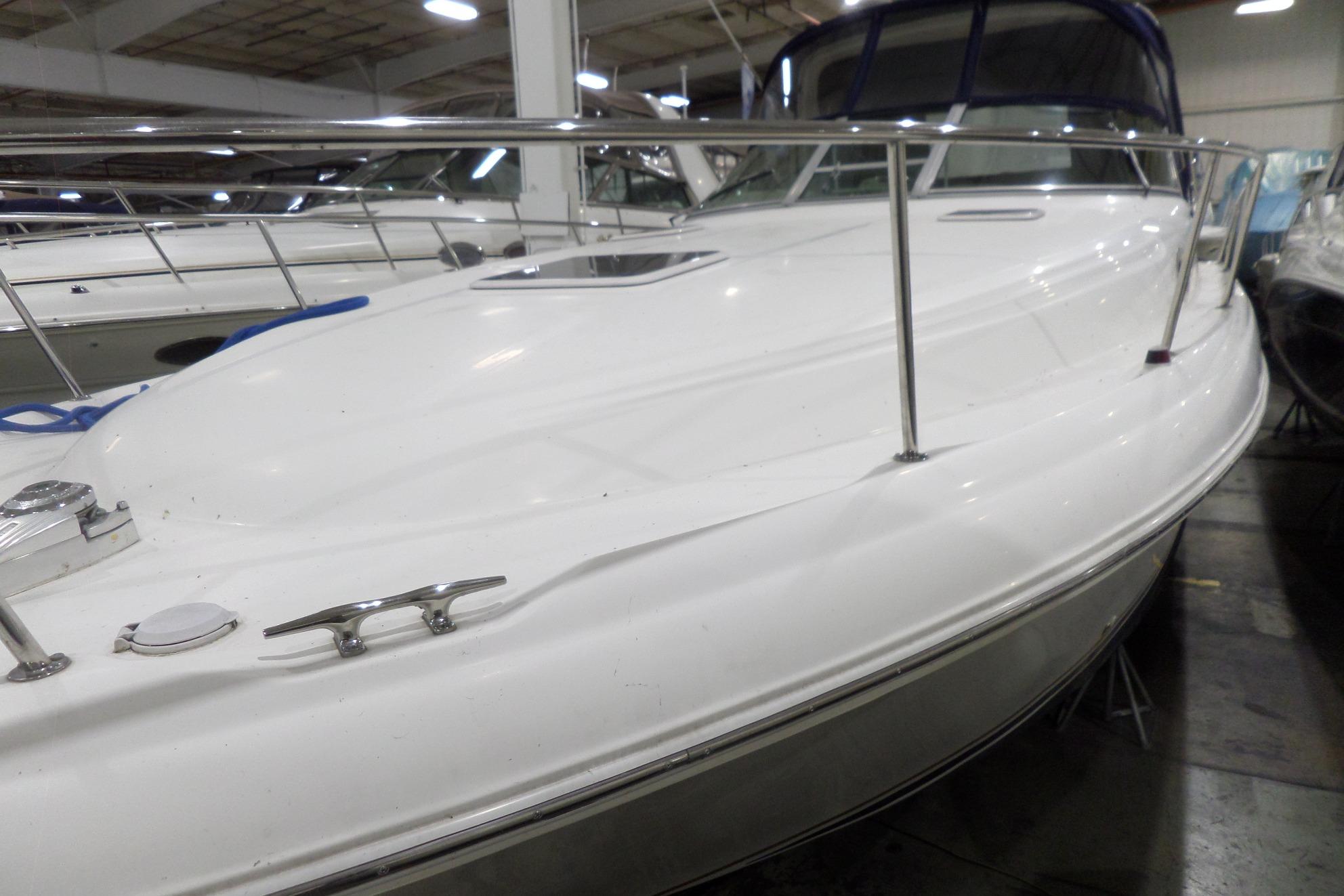 2000 Sea Ray 340 Sundancer boat in indoor storage, showcasing sleek white deck design.