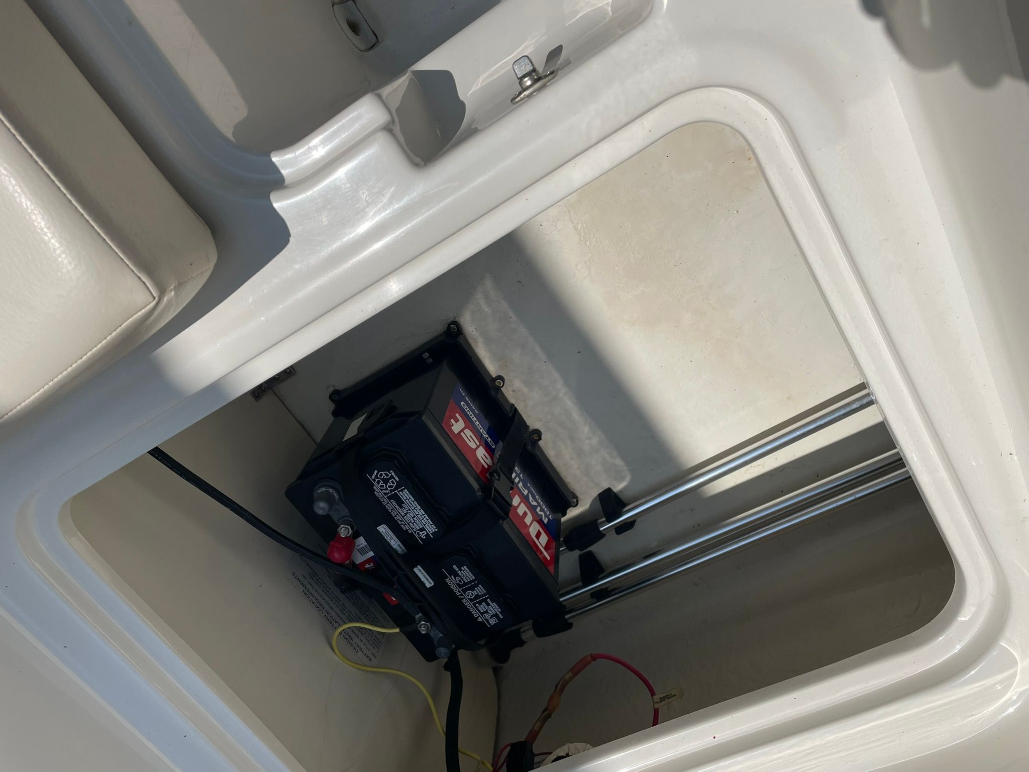 View inside a storage compartment with a battery and cables.