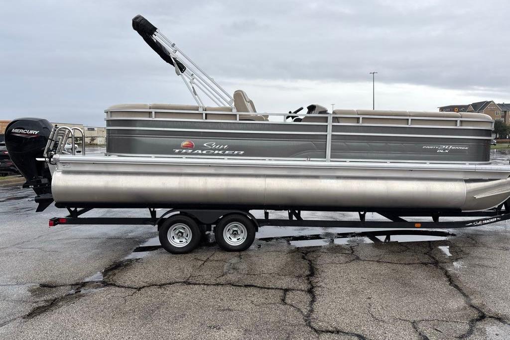 2024 Sun Tracker Party Barge 24 DLX pontoon boat on trailer, side view.