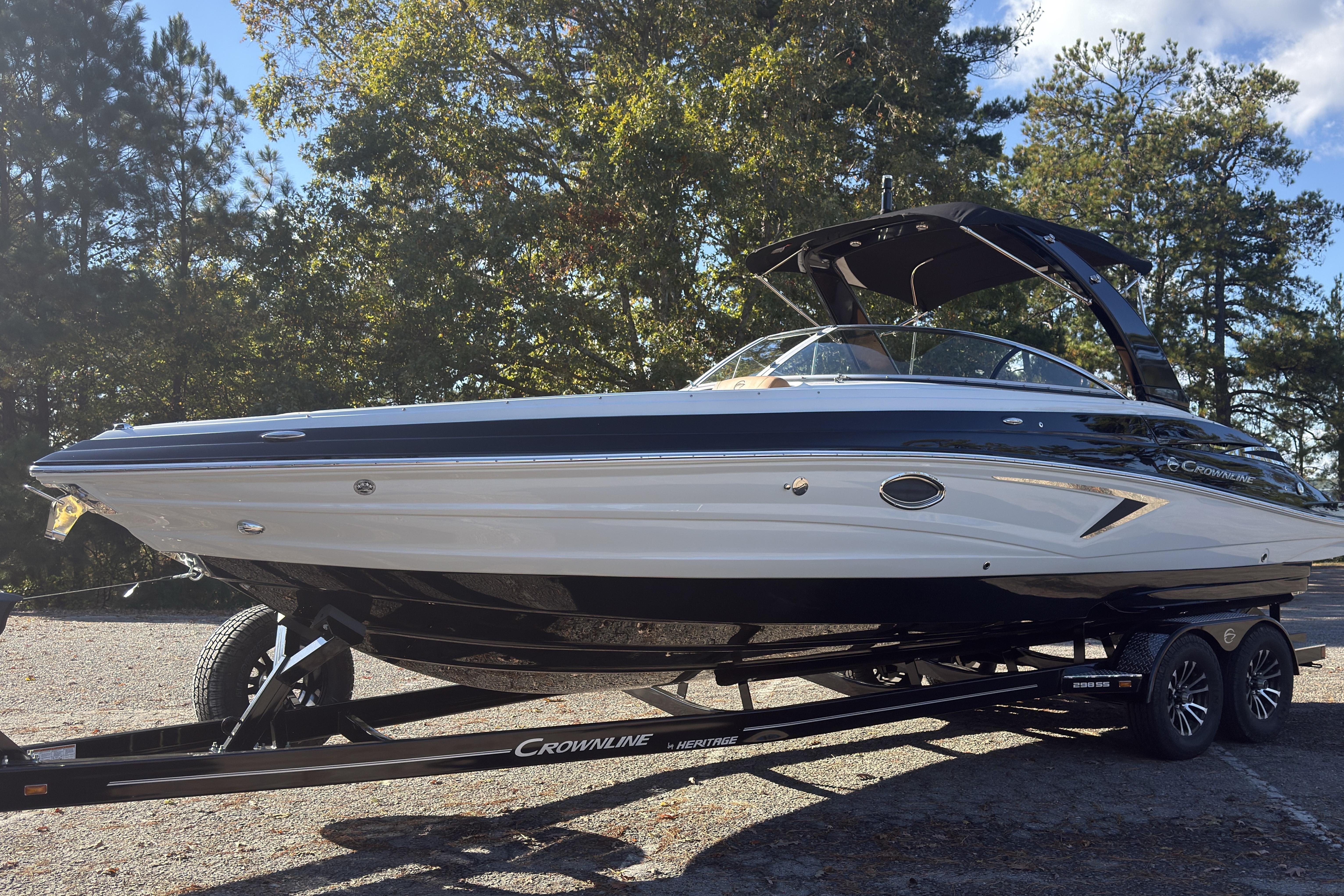 2026 Crownline 298 SS boat on trailer, parked outdoors with trees in background.