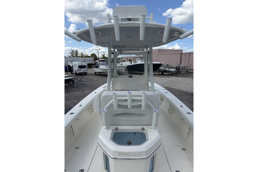 2026 Pathfinder 2800 Hybrid boat with T-top and rod holders, docked under a cloudy sky.