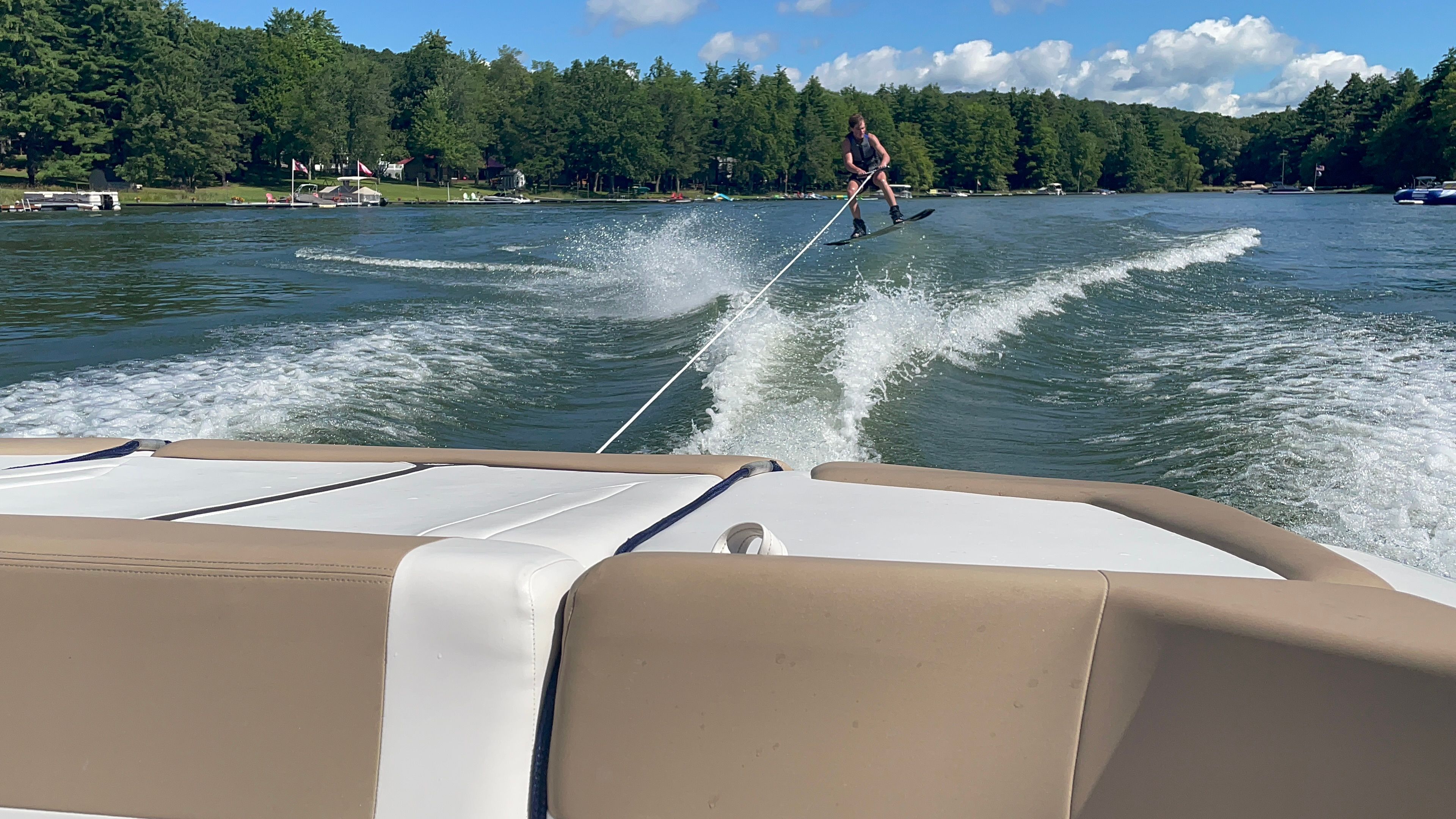 Water skier behind a Four Winns H210 boat on a lake.