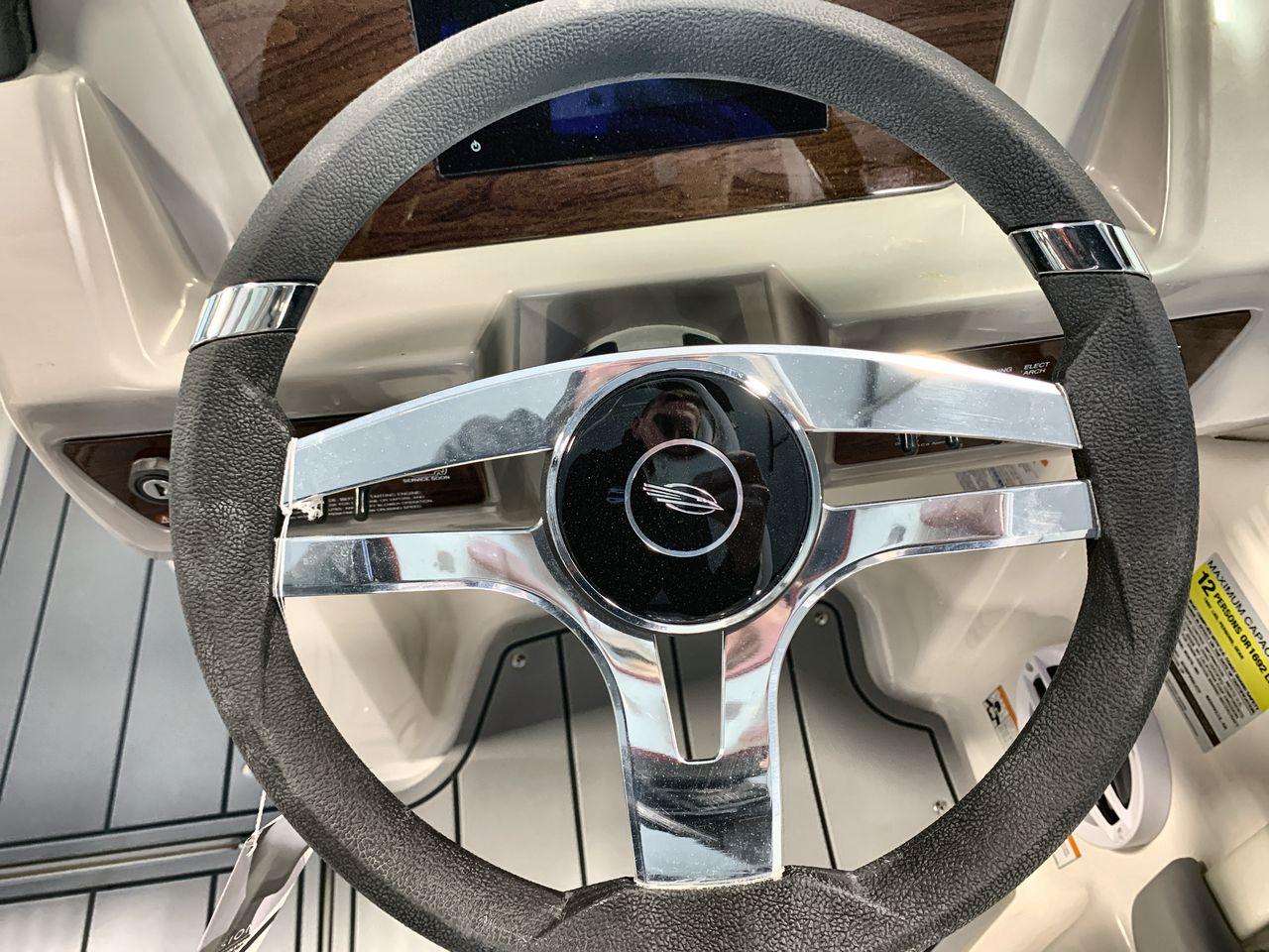 Steering wheel of 2025 Chaparral 21 SSi boat, featuring sleek chrome accents.