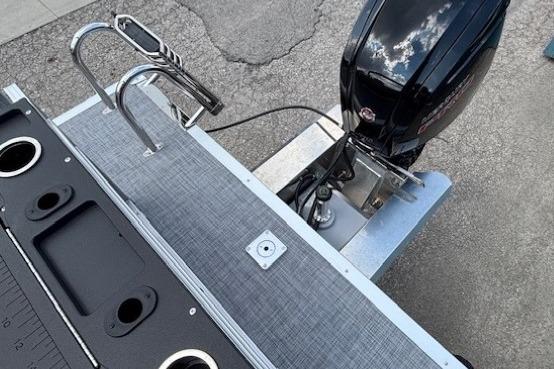 2026 Sun Tracker SportFish 20 DLX boat with motor and swim ladder.