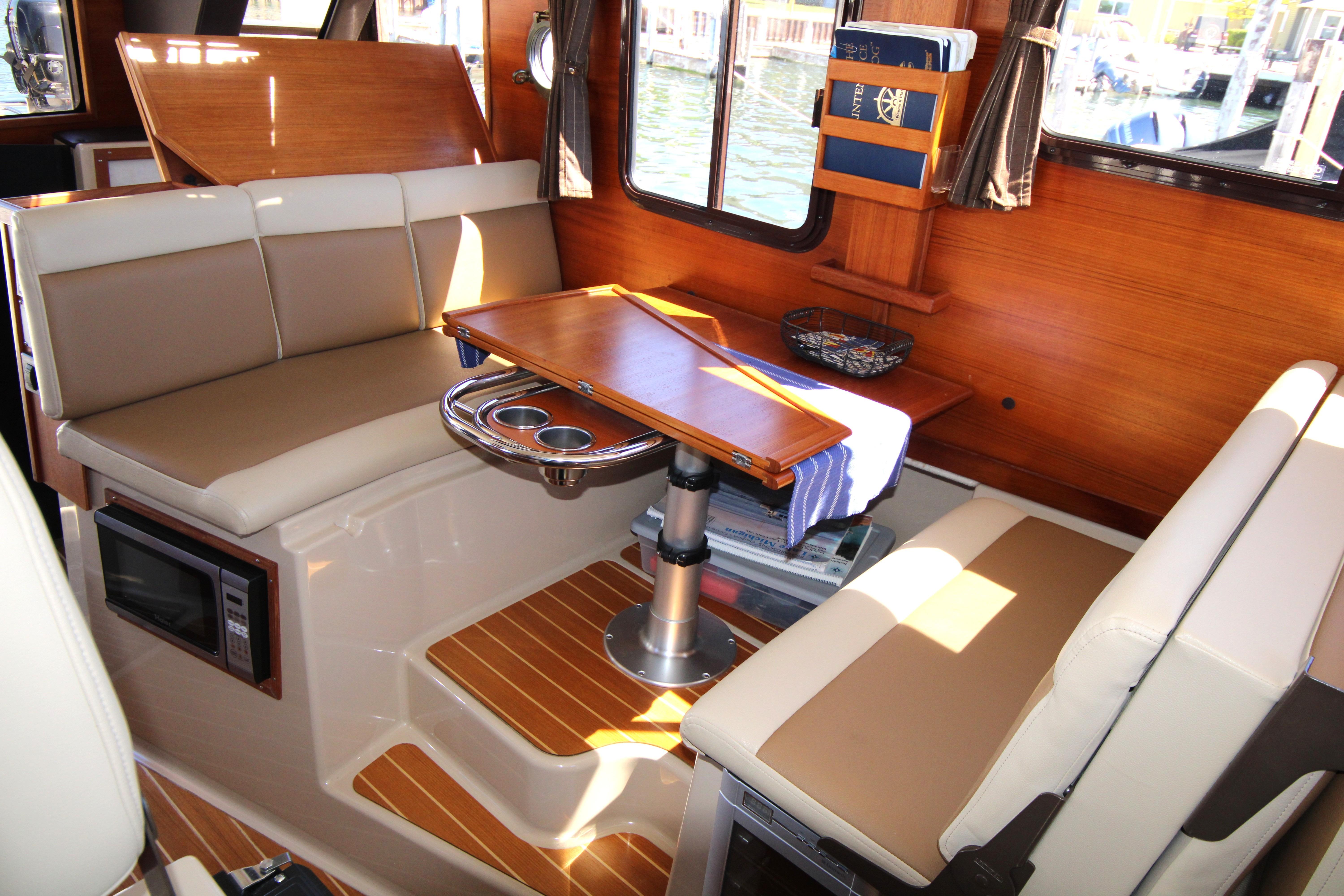 Interior of 2013 Ranger Tugs R-31 CB with seating, table, and wood accents.