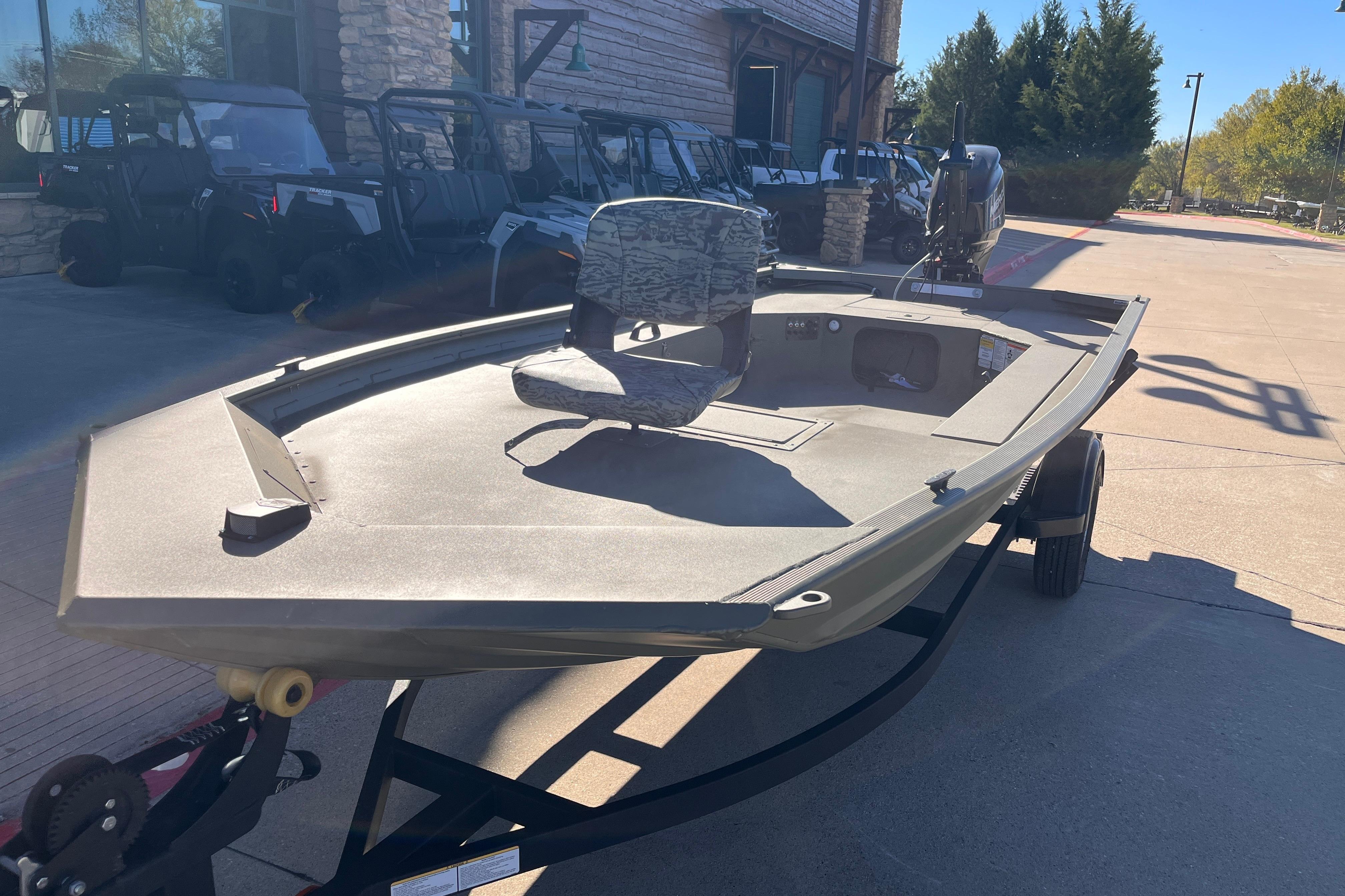 2026 Tracker Grizzly 1654 T Sportsman boat on trailer, parked outdoors.
