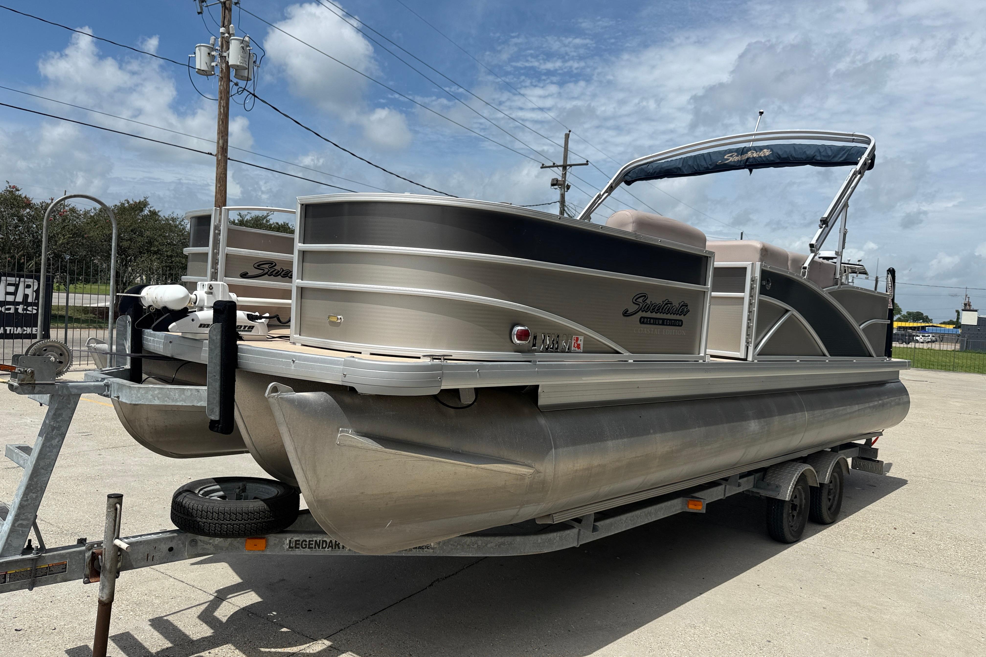 2014 Godfrey Sweetwater 2486 C pontoon boat on trailer under cloudy sky.