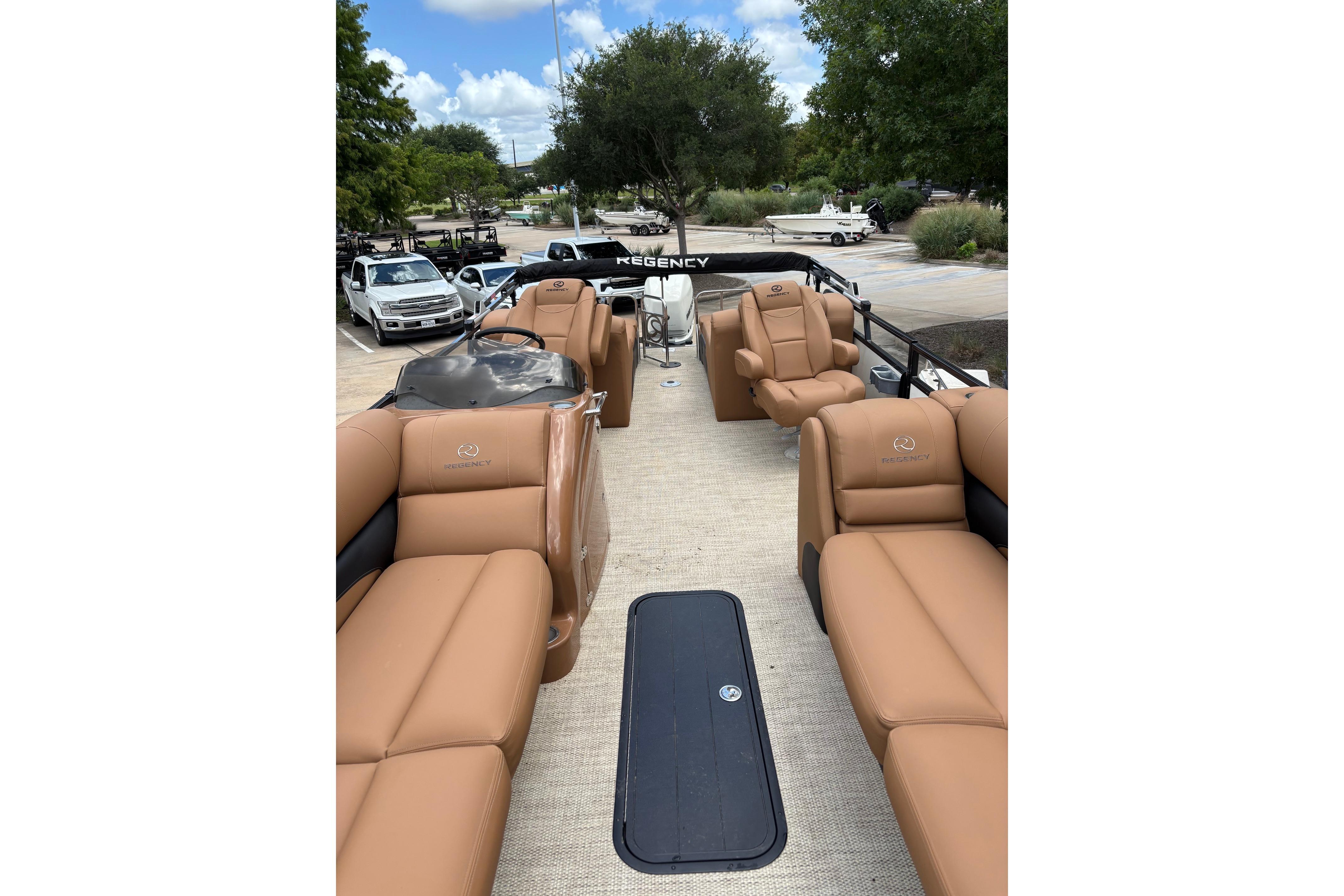 2018 Regency 254 LE3 Sport pontoon boat with tan seating and spacious deck.