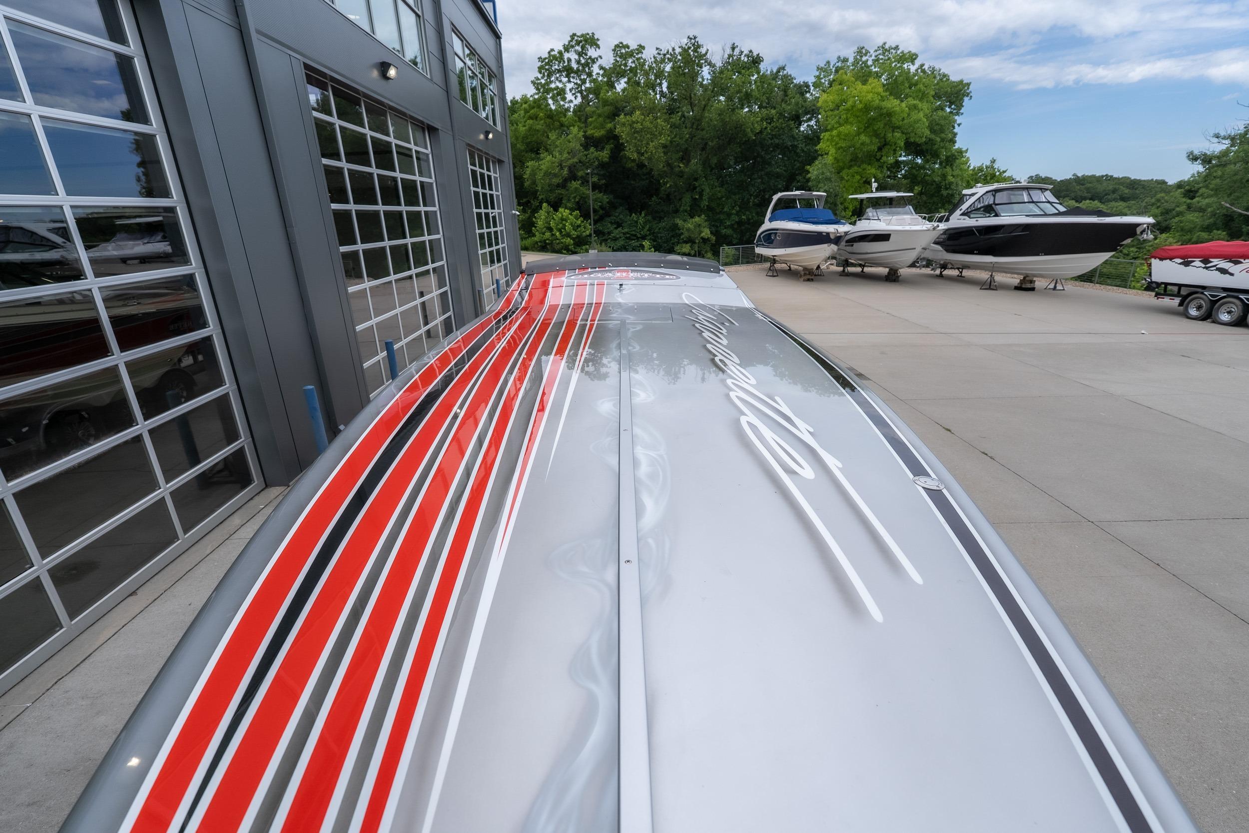 2006 Cigarette 39' Top Gun Unlimited boat with sleek red and black stripes.