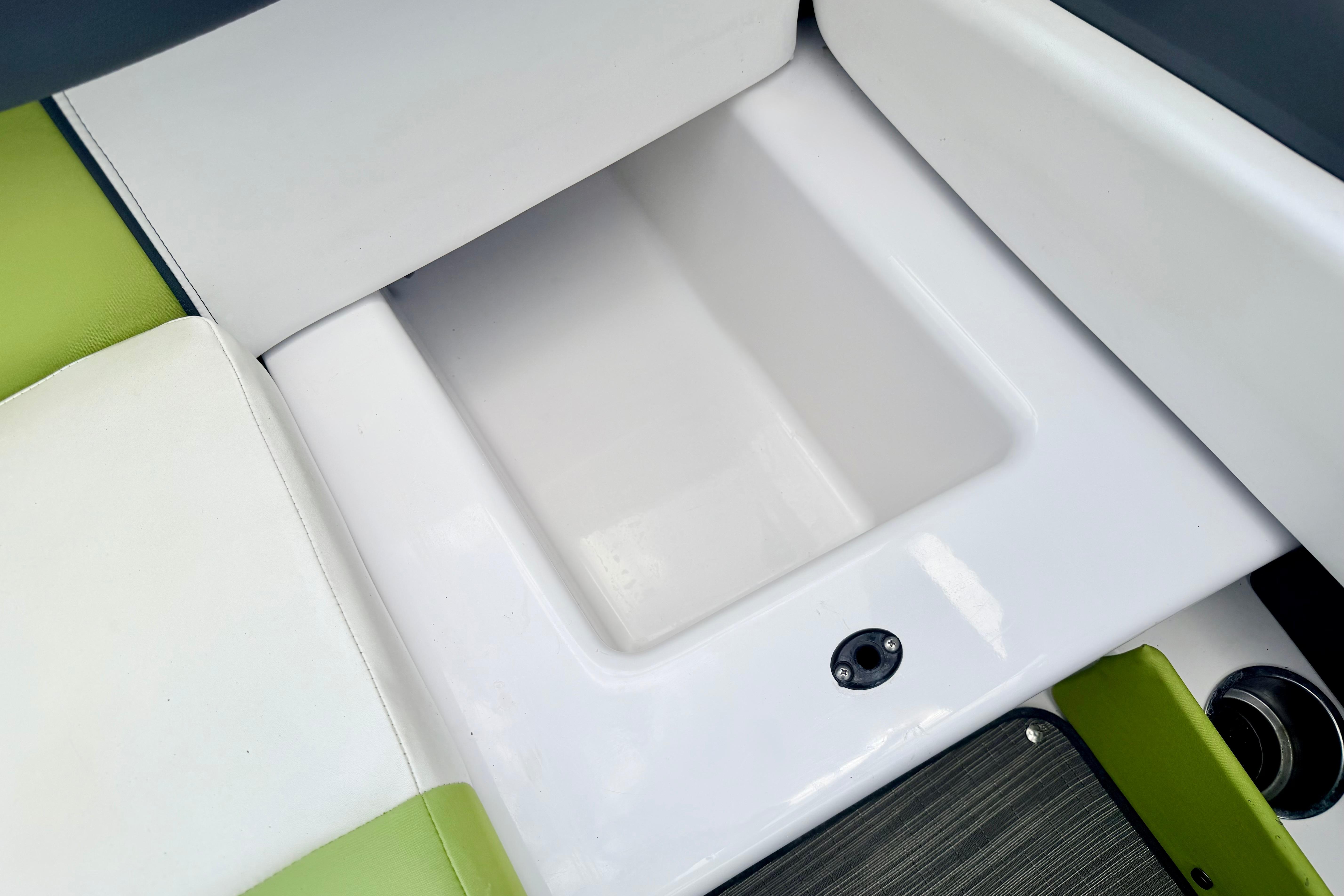2018 Glastron GT 185 boat interior storage compartment with white and green seating.